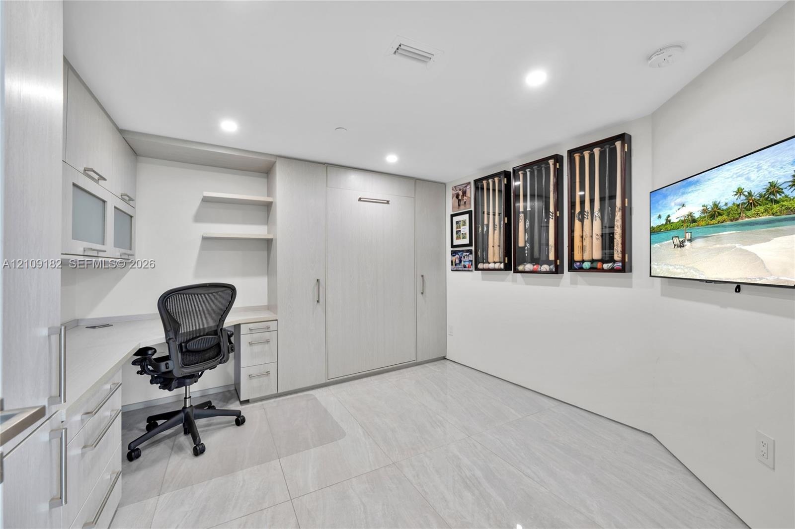 Contemporary kitchen featuring flat-panel cabinetry, a stone-surfaced kitchen island, integrated appliances, and large-format tile flooring