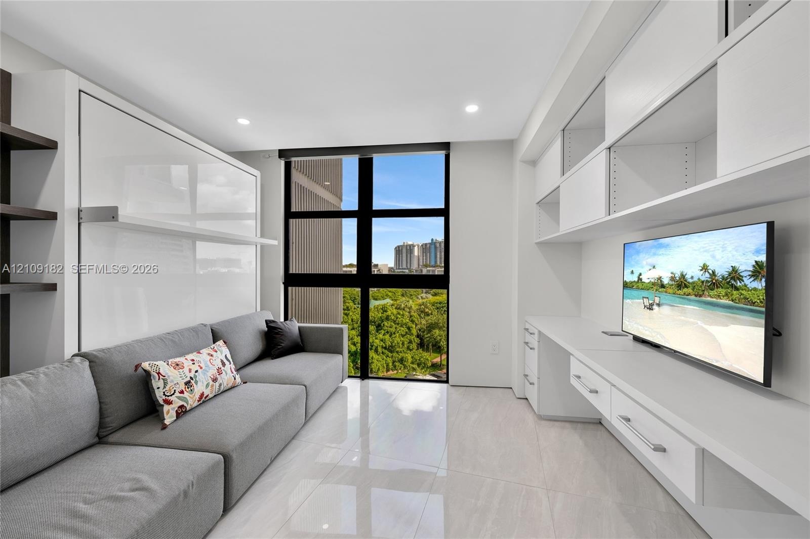 Covered balcony featuring large-format tile flooring and a glass-paneled railing