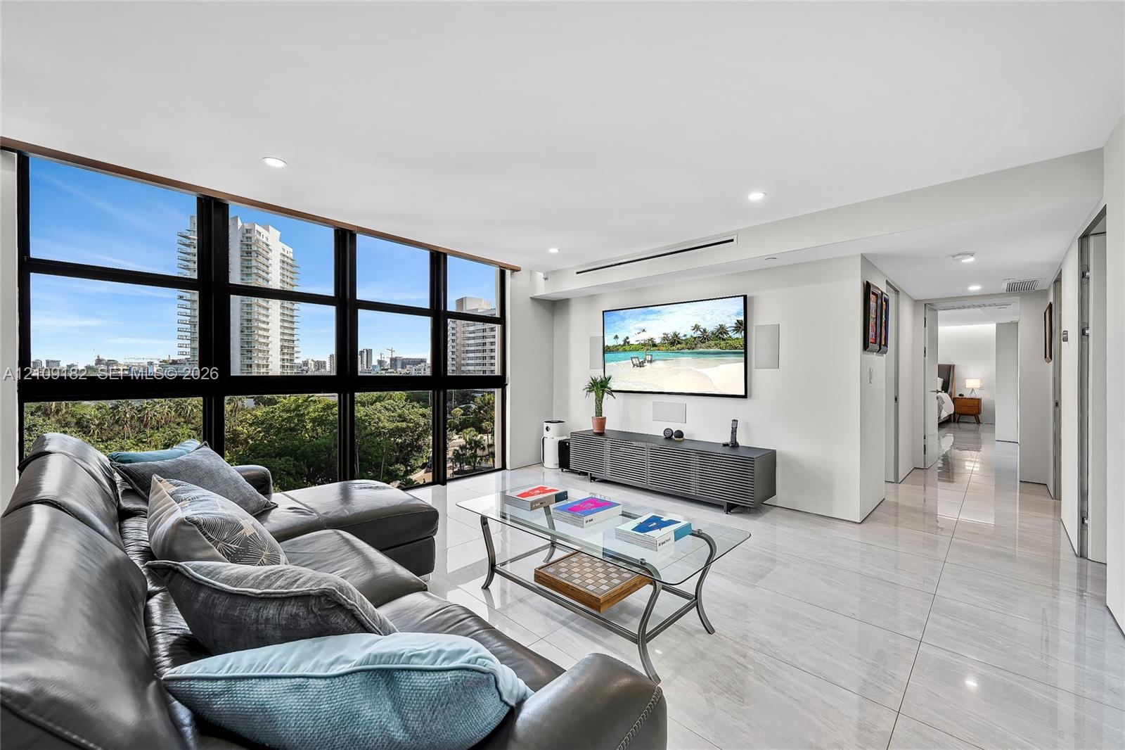 Floor-to-ceiling windows with black framing, polished stone flooring, and recessed ceiling lighting