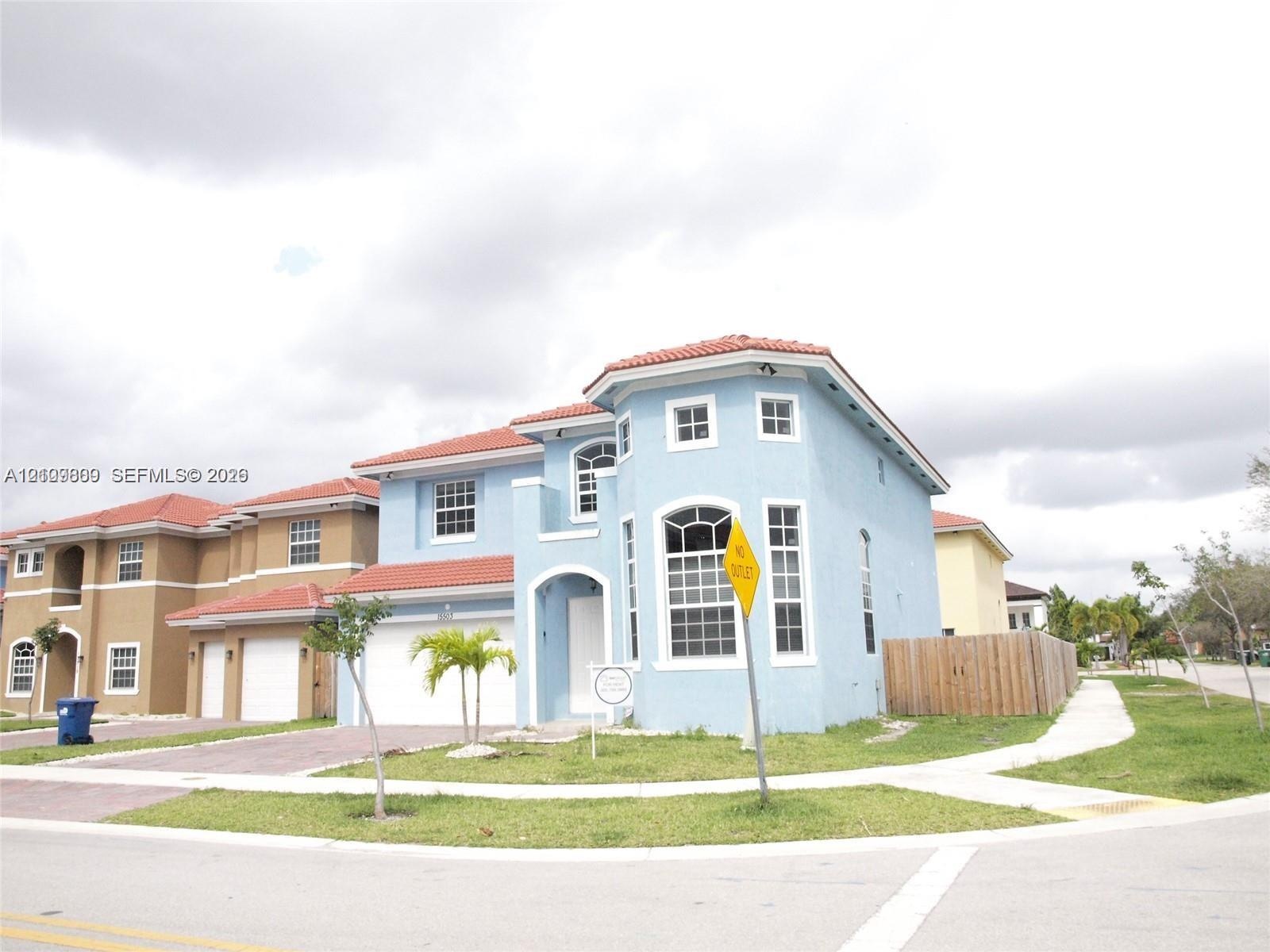 Two-story residence featuring a Mediterranean-inspired exterior, tiled roof, arched entryway, and attached garage