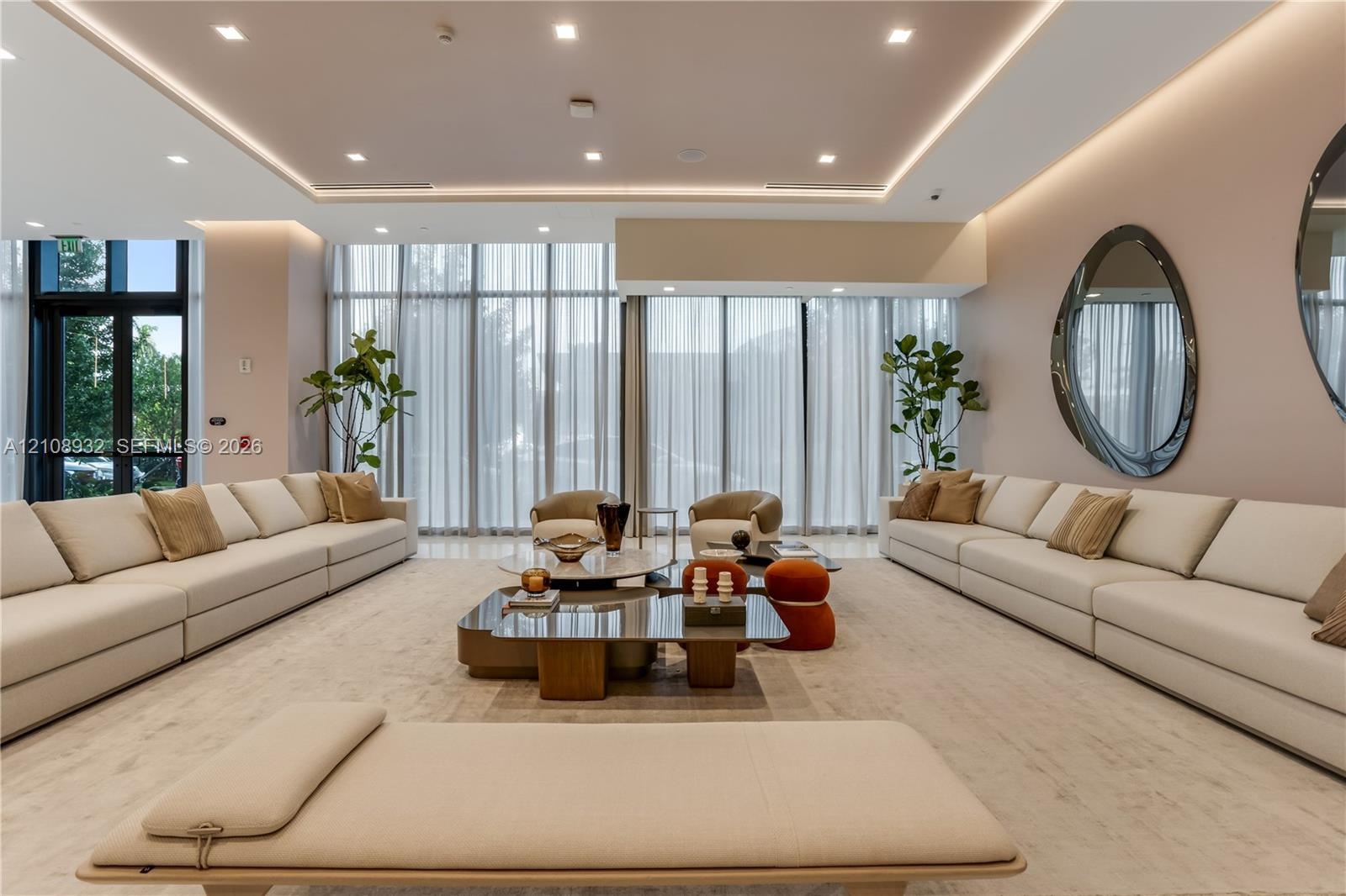 Floor-to-ceiling windows with floor-length drapery, recessed tray ceiling with integrated cove lighting, recessed overhead lighting, and light-toned h