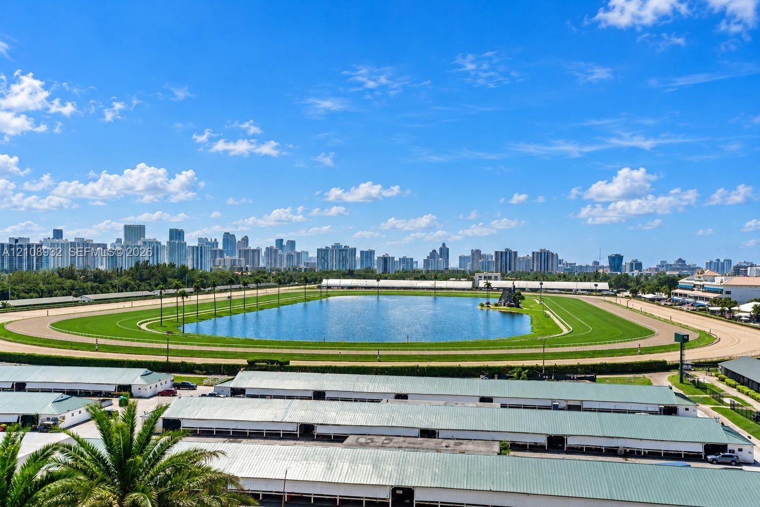 Panoramic skyline outlook featuring a sprawling racetrack, central lake, and lush green grounds