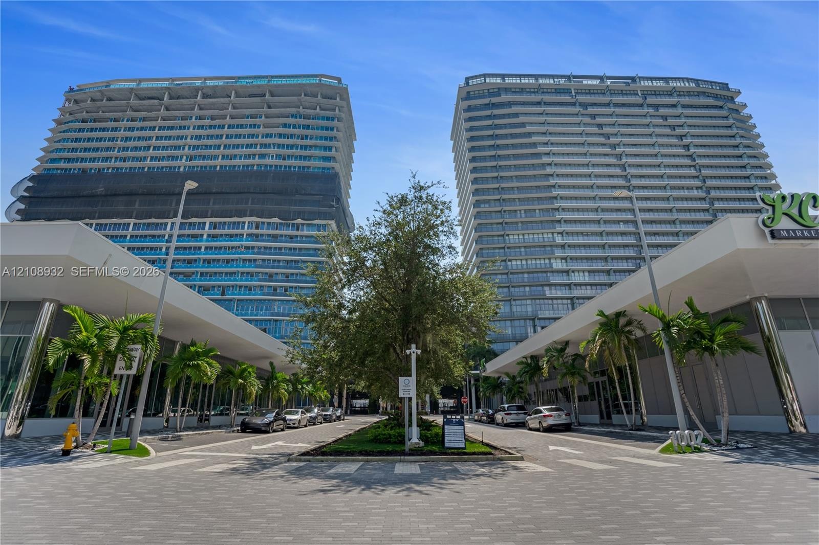 High-rise residential towers featuring glass-curtain facades, expansive balconies, integrated ground-level retail, and professionally landscaped paved