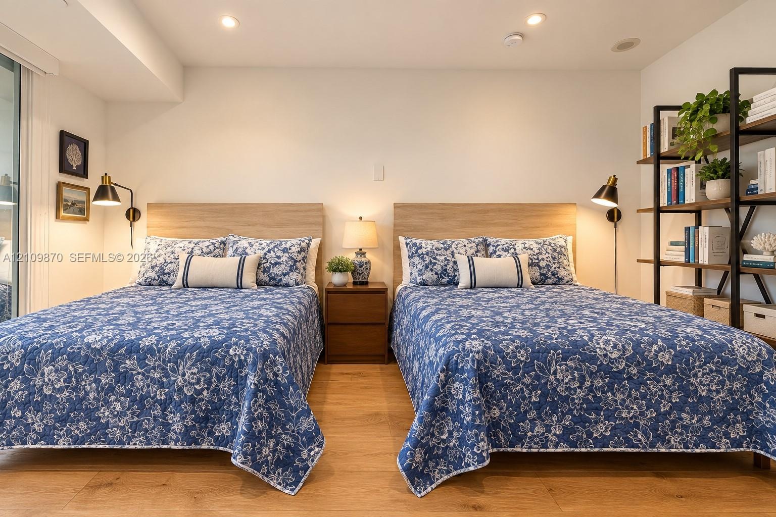 Bedroom featuring wood-finish flooring, recessed ceiling lighting, and dual wall-mounted adjustable reading lamps