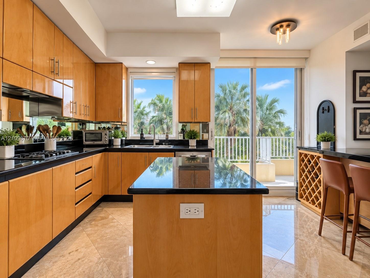 Kitchen featuring flat-panel wood cabinetry, dark stone countertops, a central island, built-in wine storage, and tile flooring