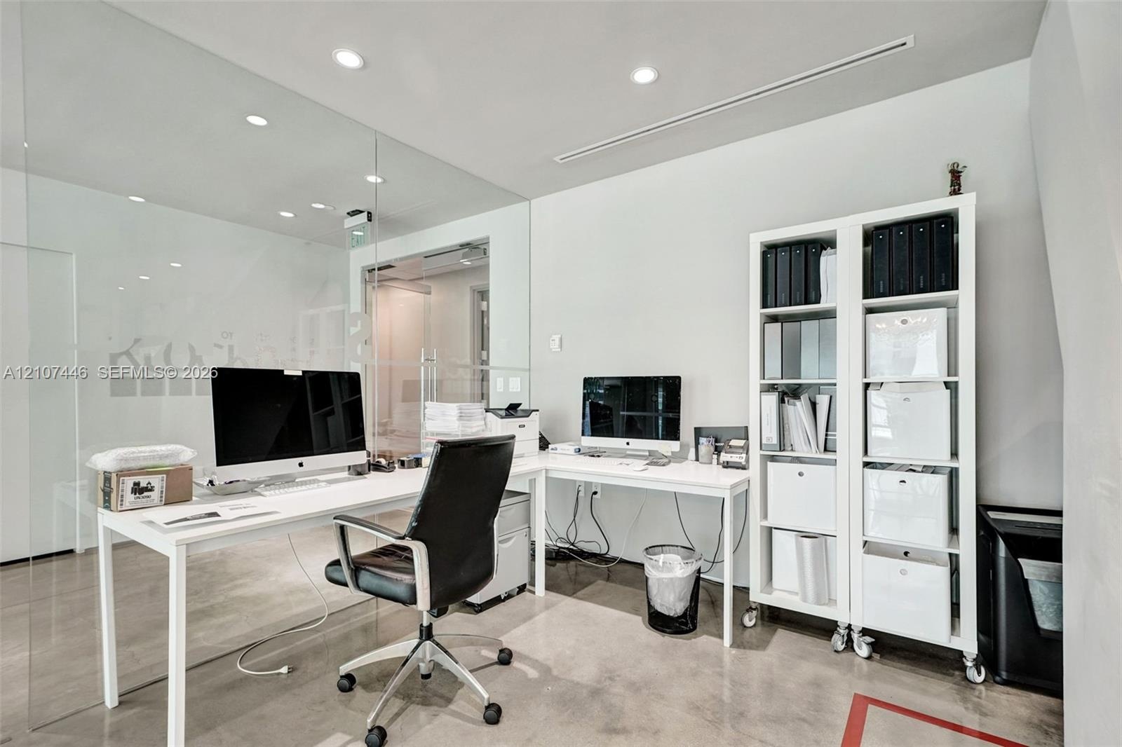 Polished concrete flooring, floor-to-ceiling glass wall partition, and recessed ceiling lighting