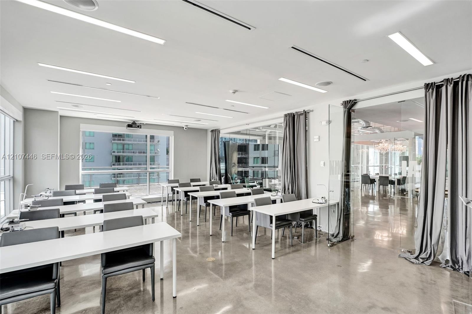 Open-concept room featuring polished concrete flooring, linear recessed lighting, floor-to-ceiling glass windows, and a glass-enclosed partitioned spa