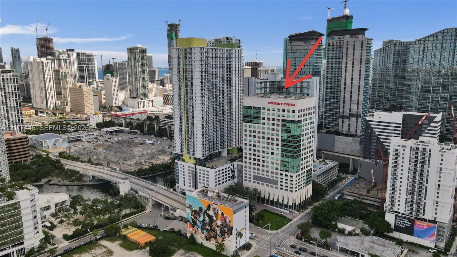 High-rise commercial building featuring a glass facade, a multi-story parking structure, and an urban location within a metropolitan district