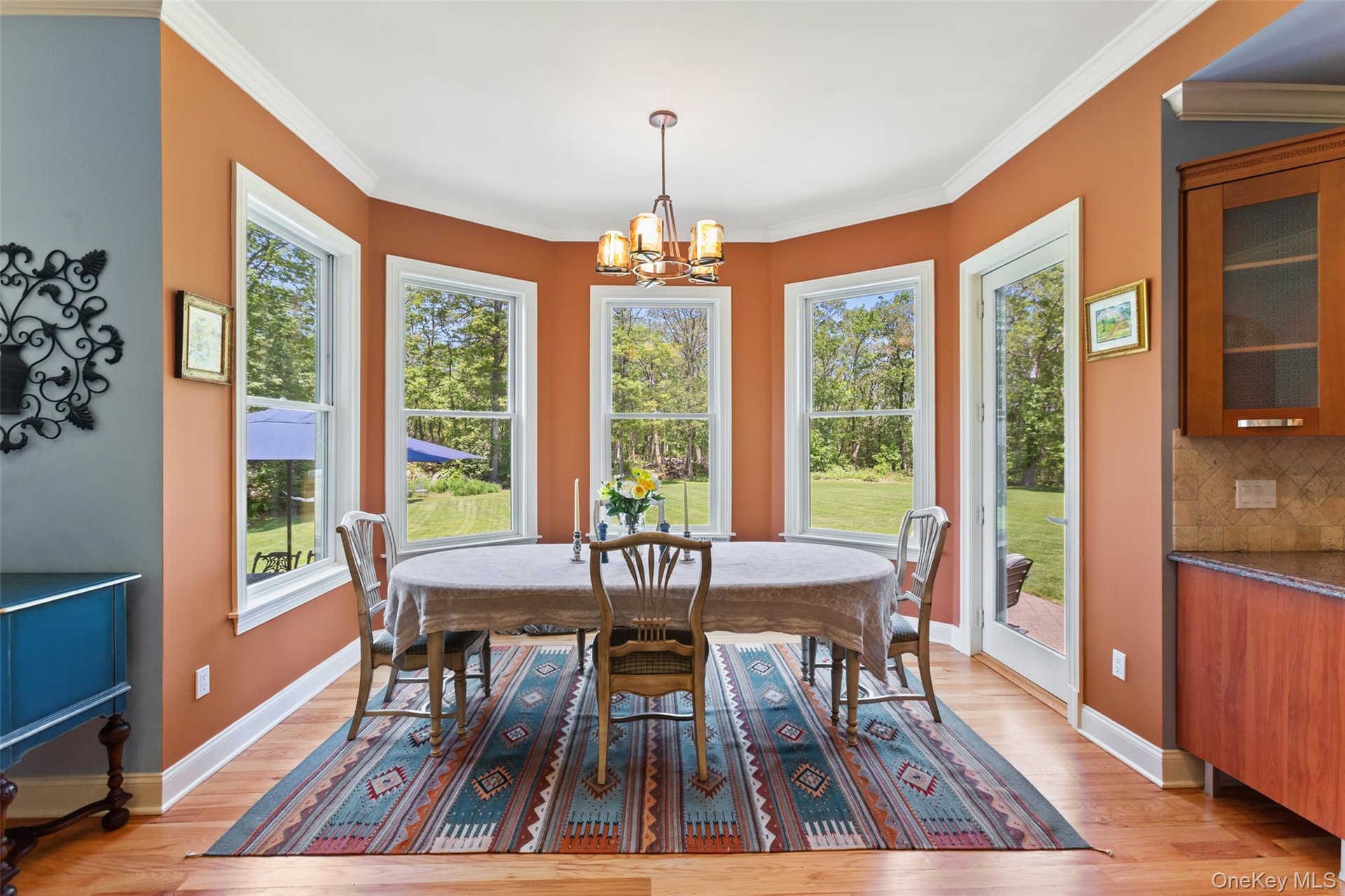 Dining area featuring plenty of natural light, a chandelier, light wood-style flooring, and crown molding