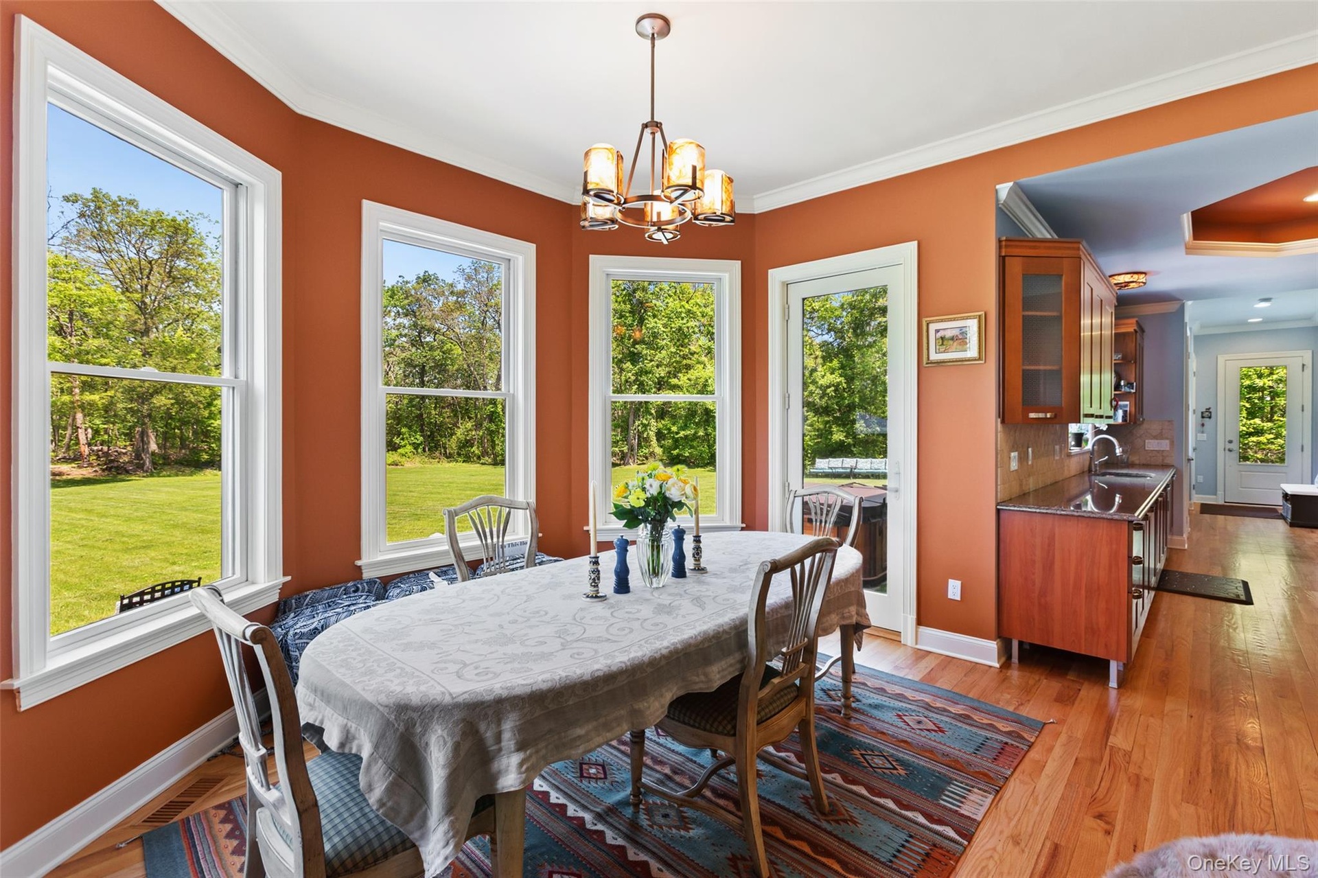 Dining area with a chandelier, baseboards, crown molding, and light wood-type flooring