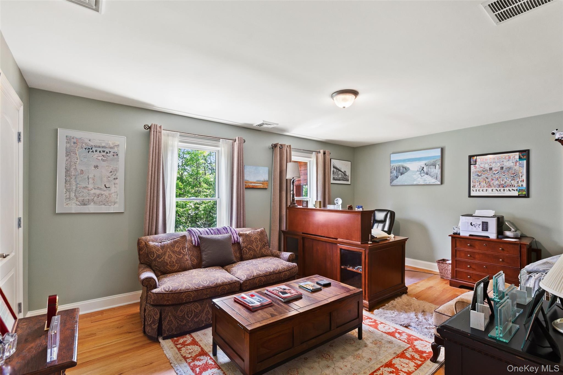 Bedroom with light wood-style flooring, baseboards, and an office area