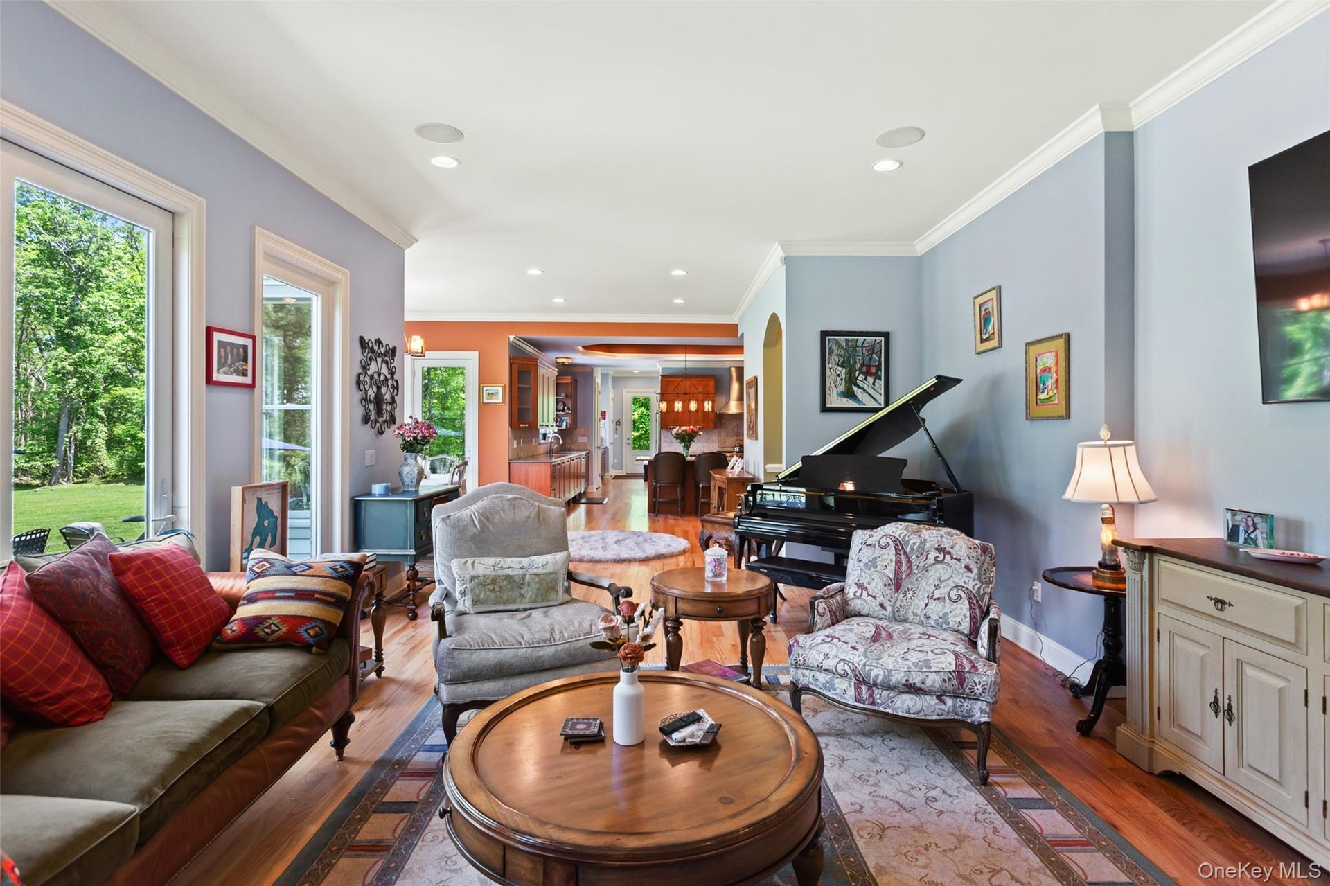 Living area featuring plenty of natural light, wood finished floors, baseboards, recessed lighting, and crown molding
