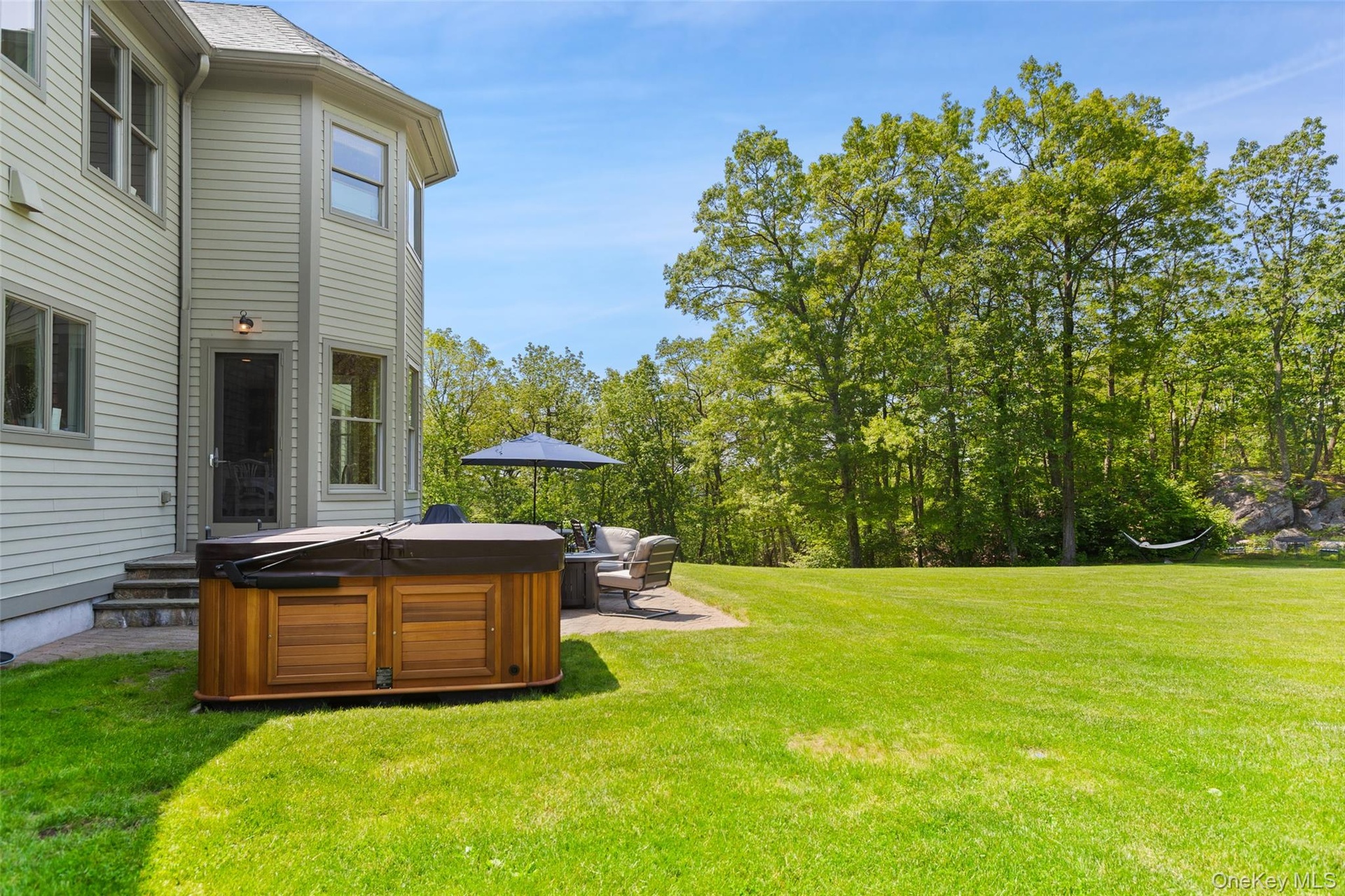 View of grassy yard featuring a hot tub