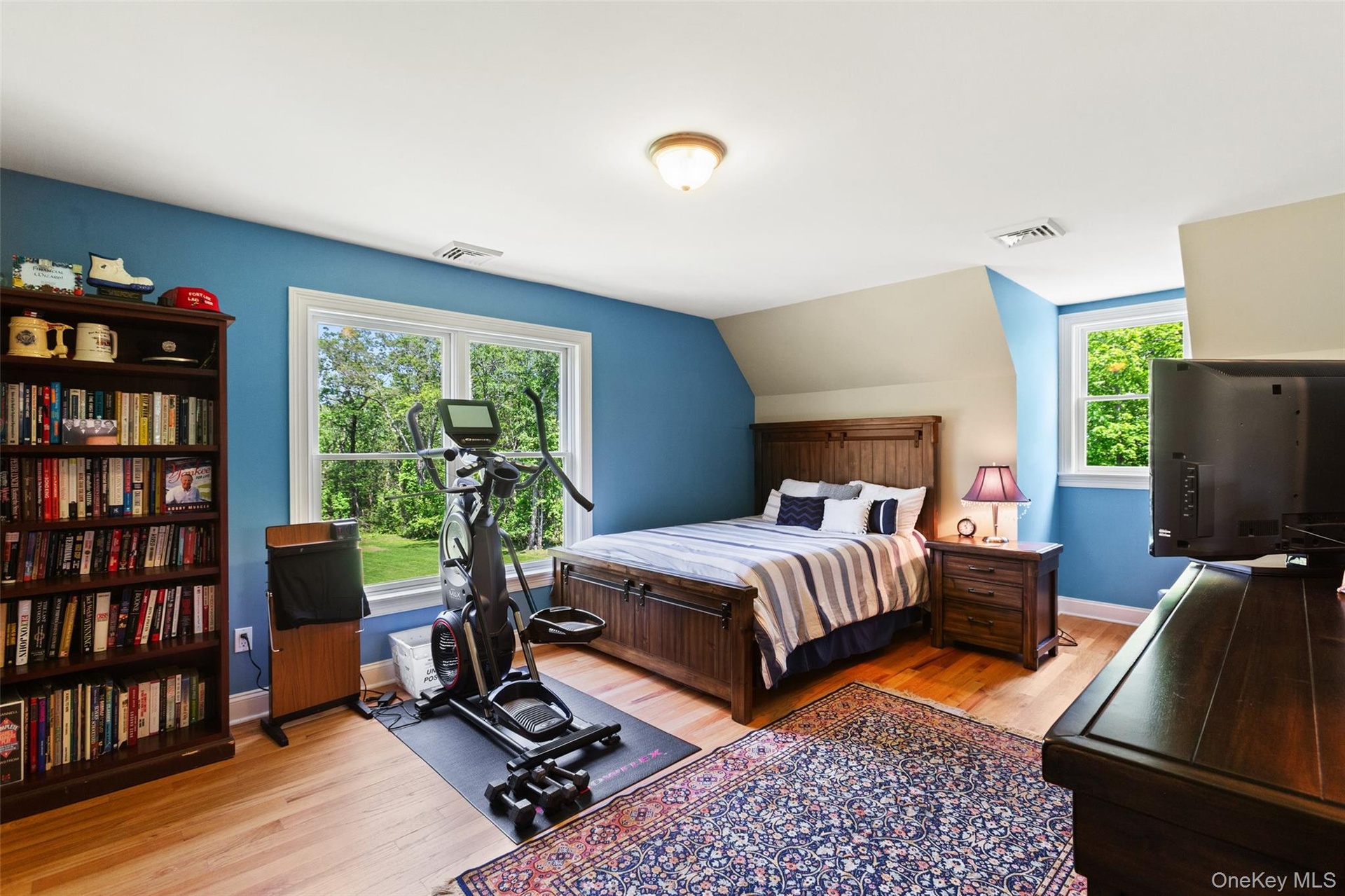 Bedroom featuring wood finished floors, baseboards, and vaulted ceiling
