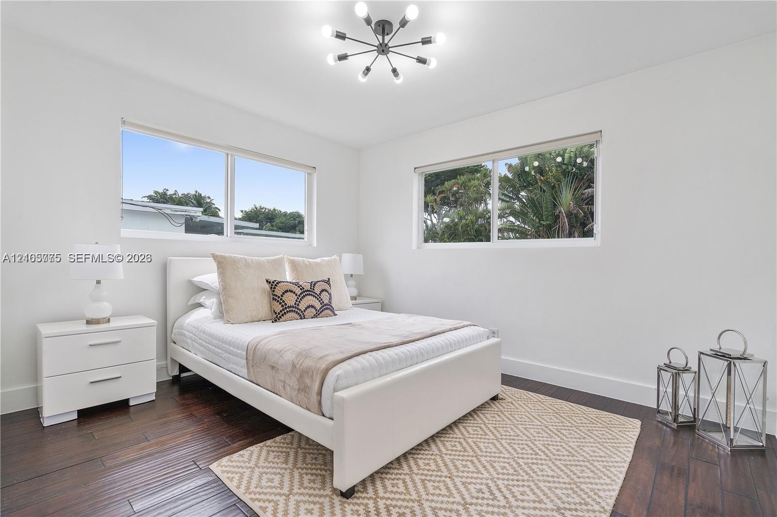 Wood-finish flooring, multi-arm sputnik-style ceiling light fixture, and dual horizontal windows