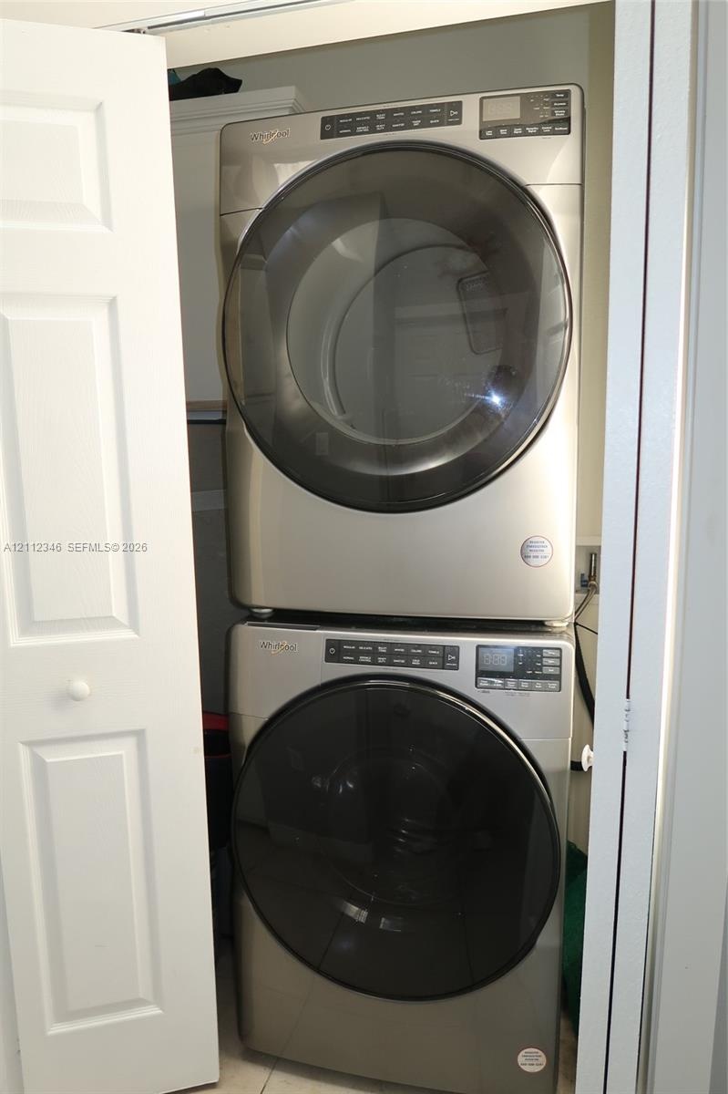Stacked front-load metallic-finish laundry set housed within a dedicated closet