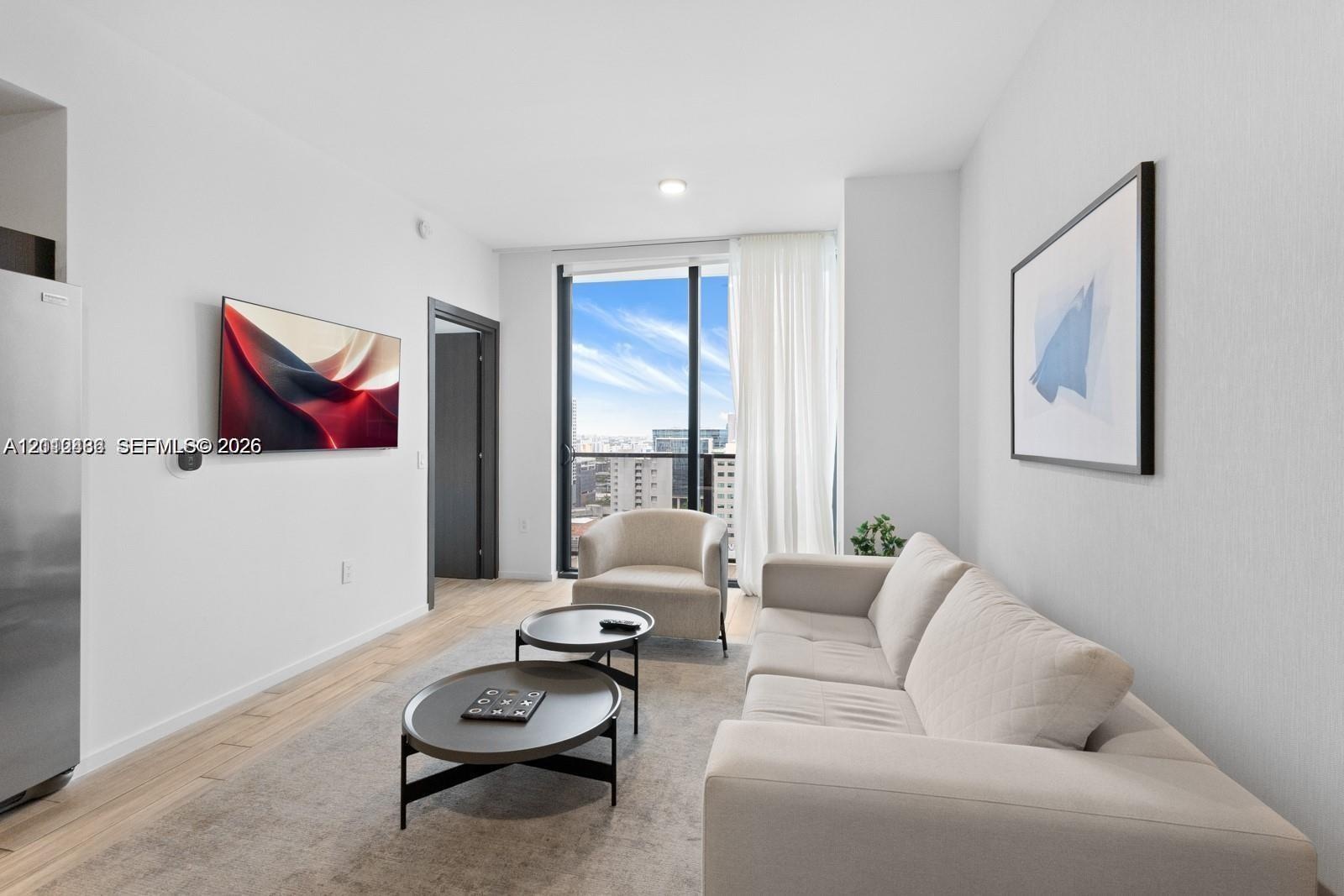 Living area featuring floor-to-ceiling windows, wood-finish flooring, and recessed ceiling lighting
