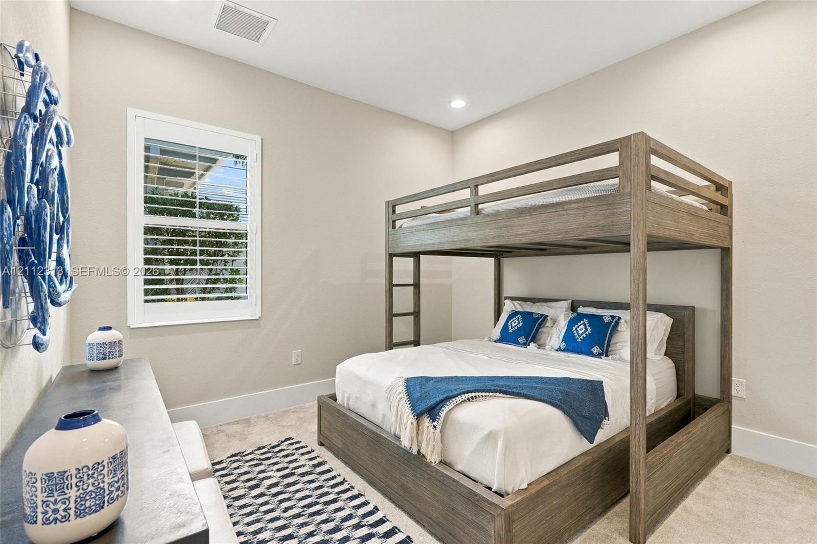 High ceilings, recessed lighting, and a single-pane window featuring custom interior shutters