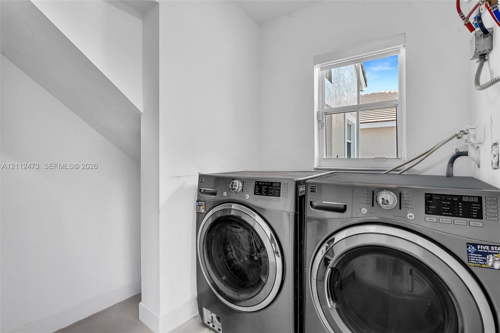 Laundry area featuring a dedicated window with natural light and a recessed nook