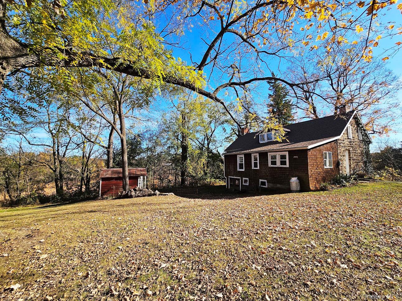Rear view of stone house, lawn & small shed