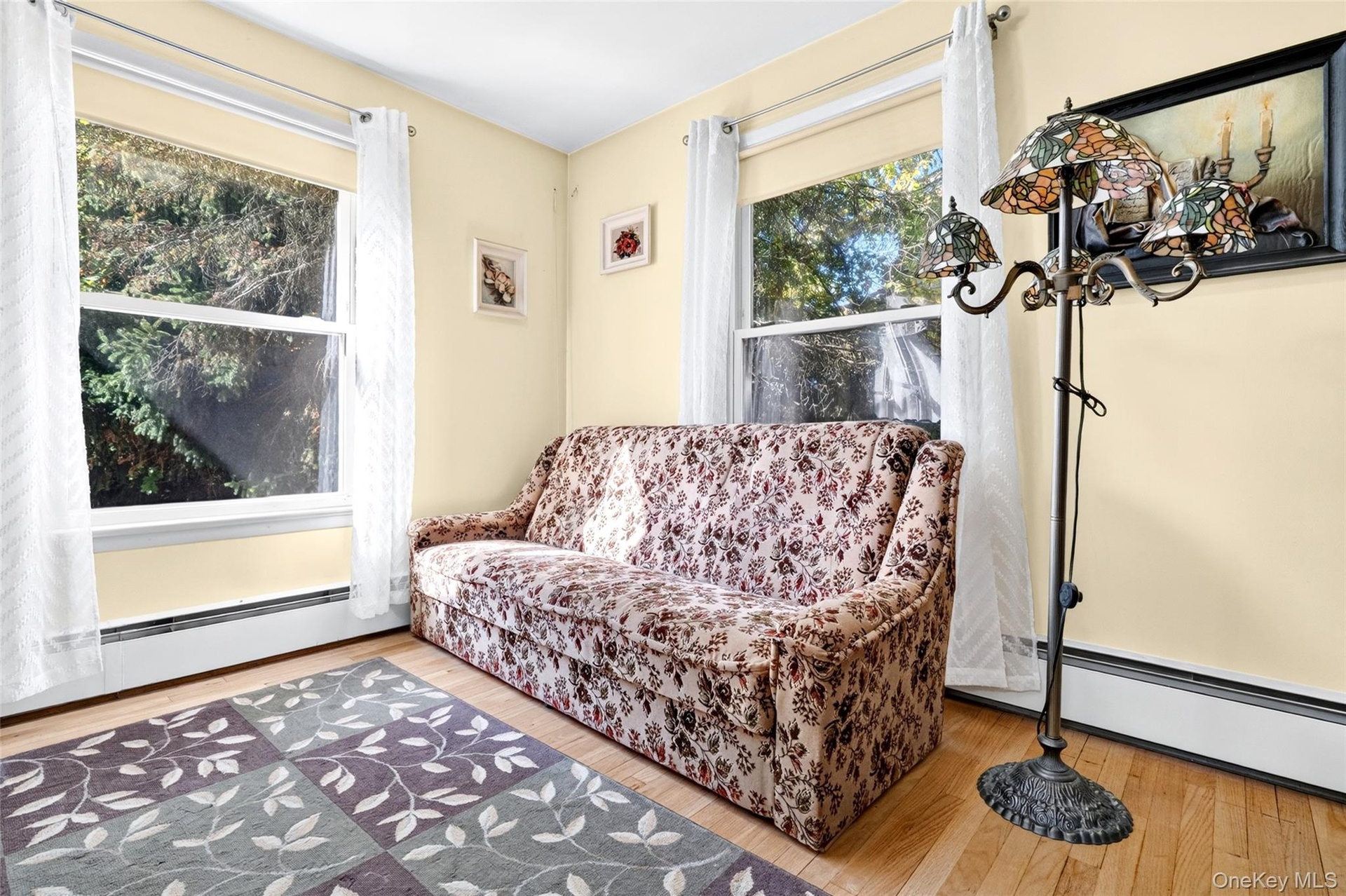 Sunny 2nd Bedroom on the 1st Floor, featuring hardwood flooring and 2 large windows.