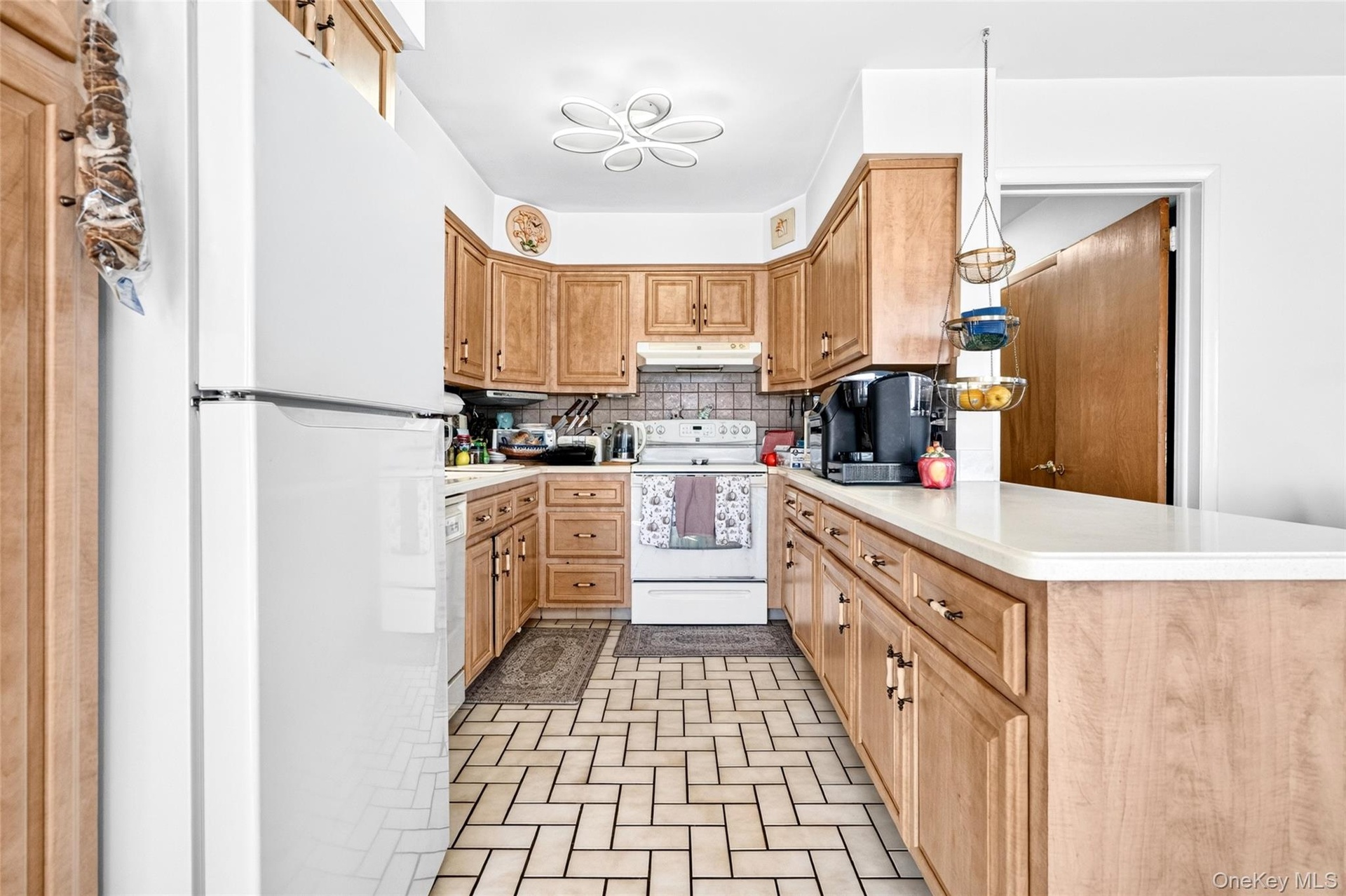 Very large kitchen with penisula, refrigerator, stove/oven and microwave.
