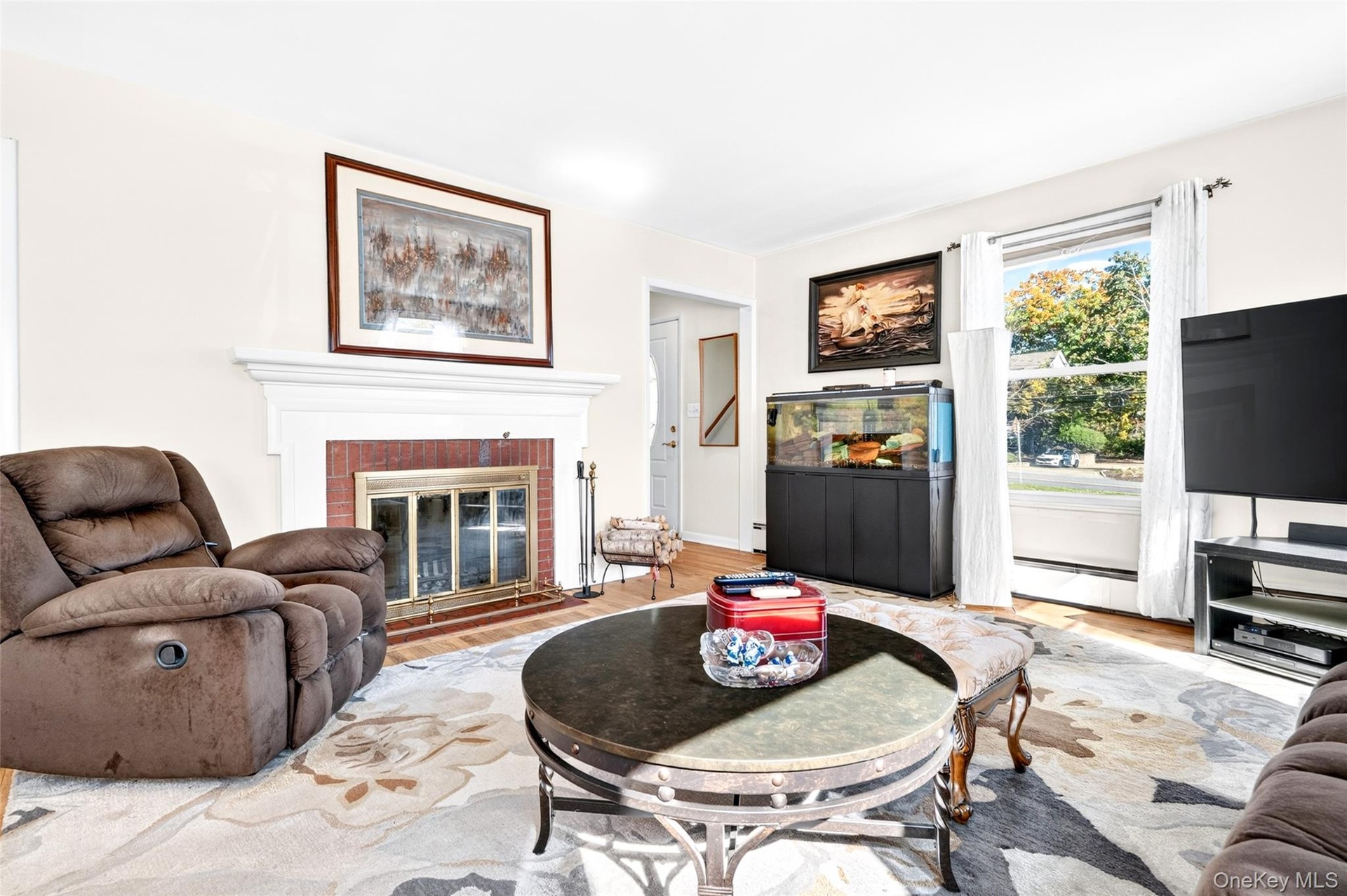 Center view of the Sunny, Huge Living Room, featuring a beautiful woodburning Fireplace.