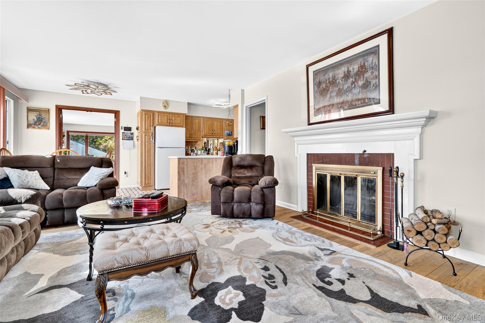 Another view of the very large, bright and inviting Living Room, featuring hardwood flooring, lots of windows, woodburing Fireplace.