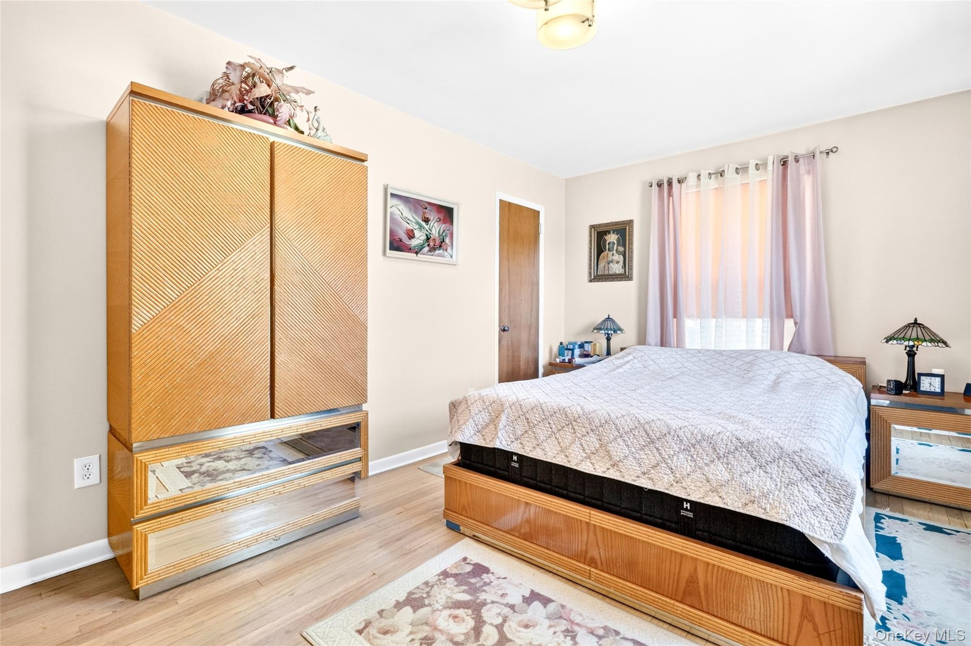 Another view of the large and bright Primary Bedroom with hardwood flooring and large windows.