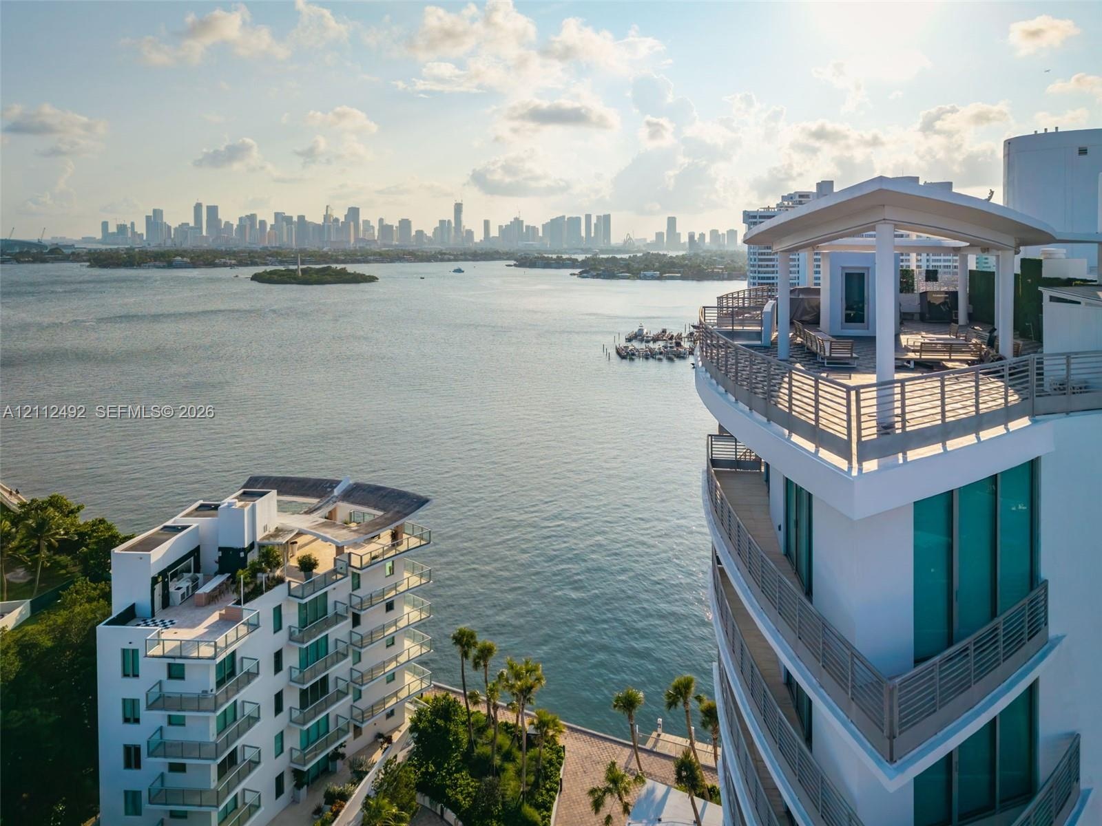 High-rise architecture featuring expansive rooftop terraces, glass-railing balconies, floor-to-ceiling windows, and waterfront positioning overlooking