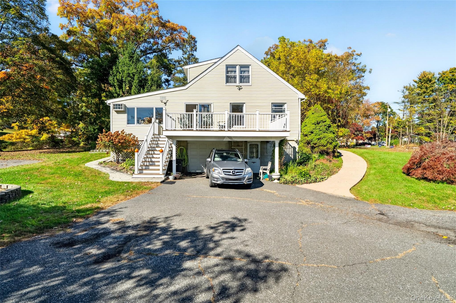 View of the left side of the home, featuring the carport, deck and driveway.