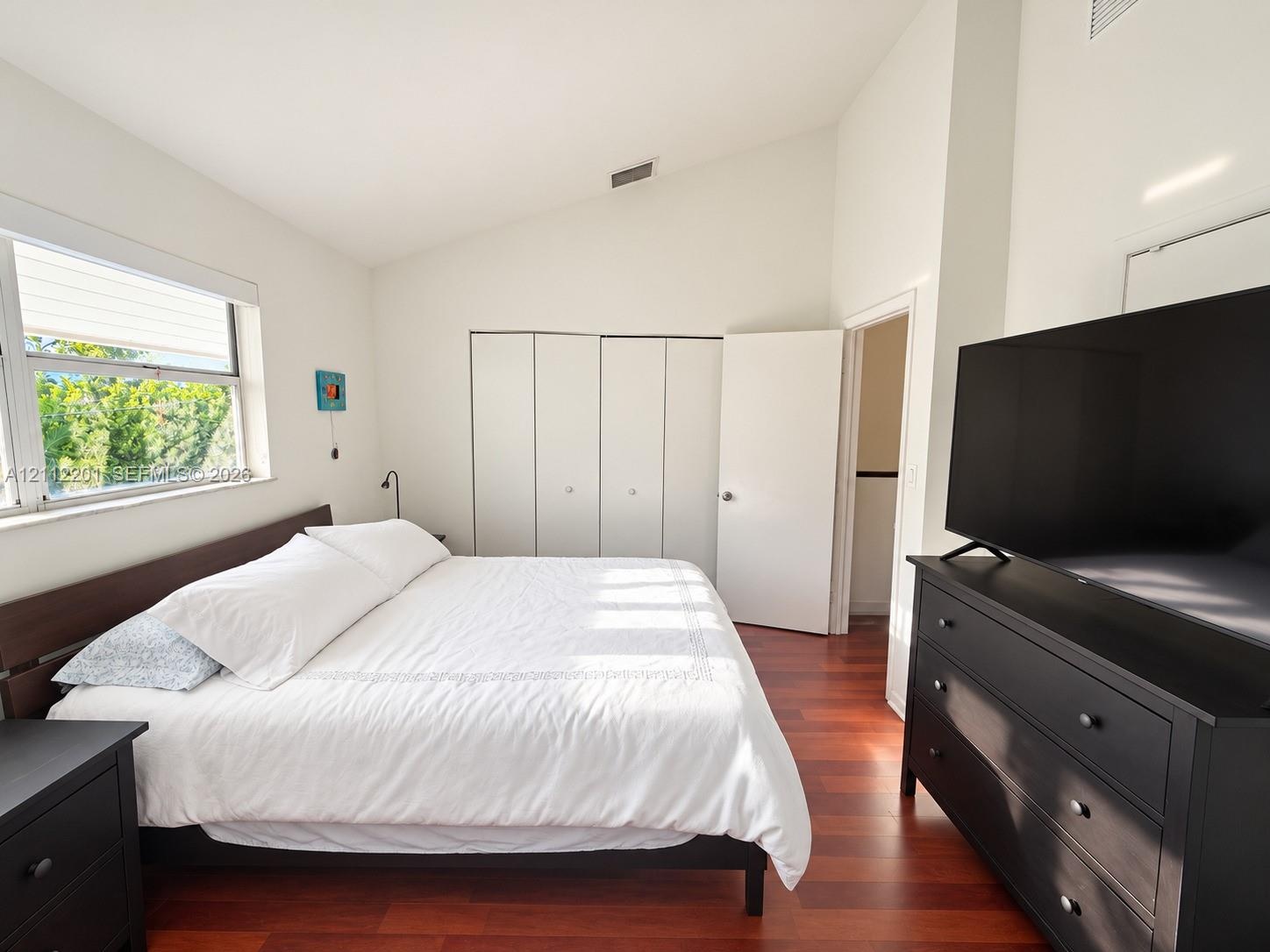 Vaulted ceiling, wood-finish flooring, and built-in closet storage