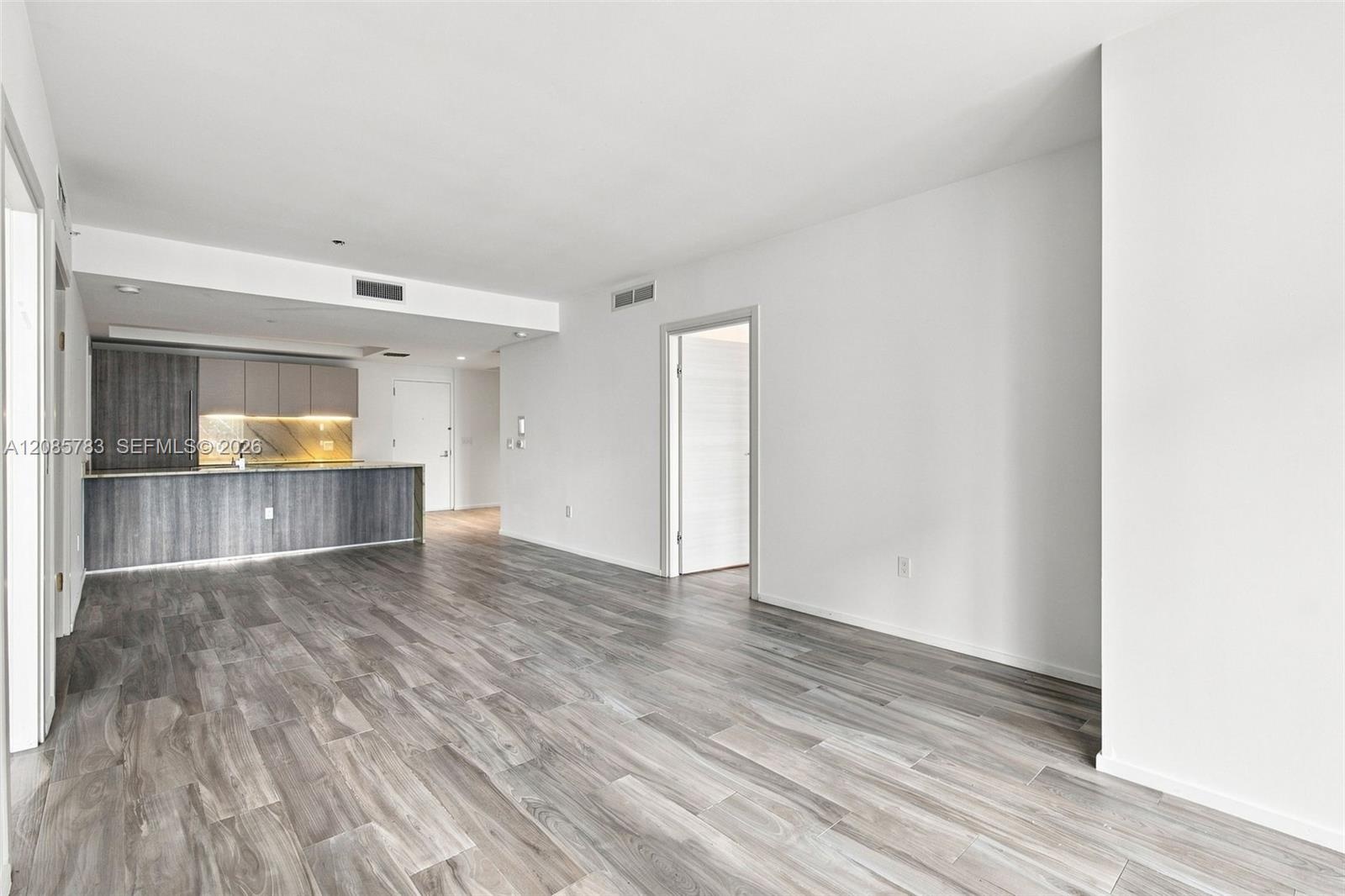 Open-concept interior featuring wood-finish flooring, two-tone cabinetry, a peninsula counter, and recessed lighting