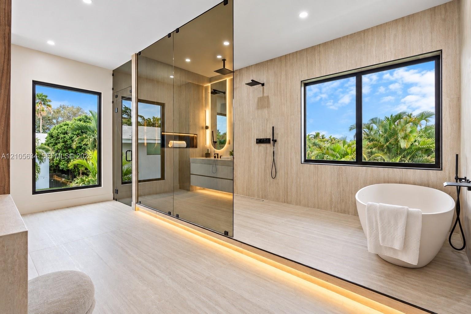 Bathroom featuring a freestanding oval soaking tub, expansive glass-enclosed shower, wood-finish wall and floor tiling, matte black fixtures, and rece
