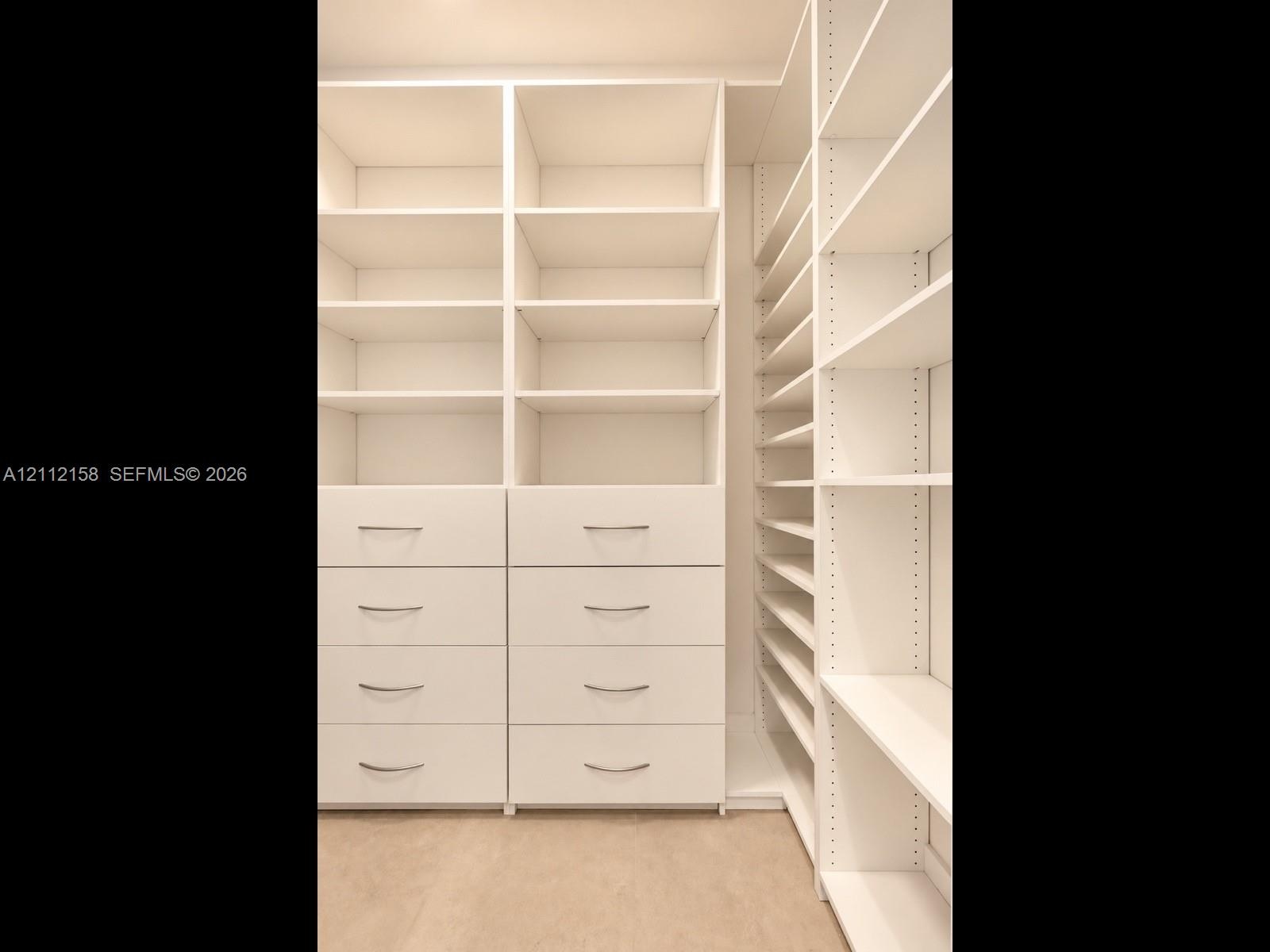 Custom floor-to-ceiling built-in storage with integrated drawers and polished hardware — a place for everything