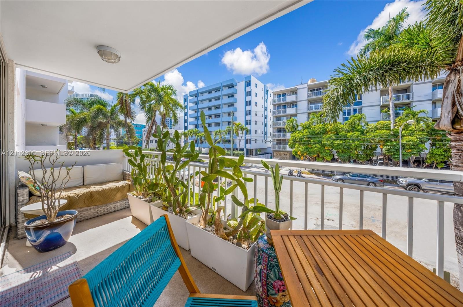 Covered balcony featuring concrete flooring and a white metal safety railing