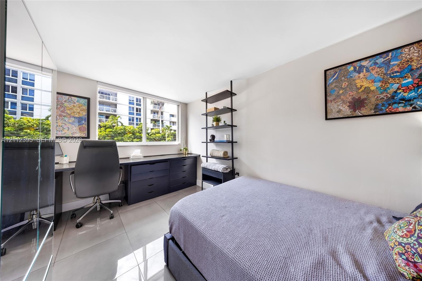 Interior room featuring large windows, neutral-toned tile flooring, and custom built-in cabinetry with a desk surface