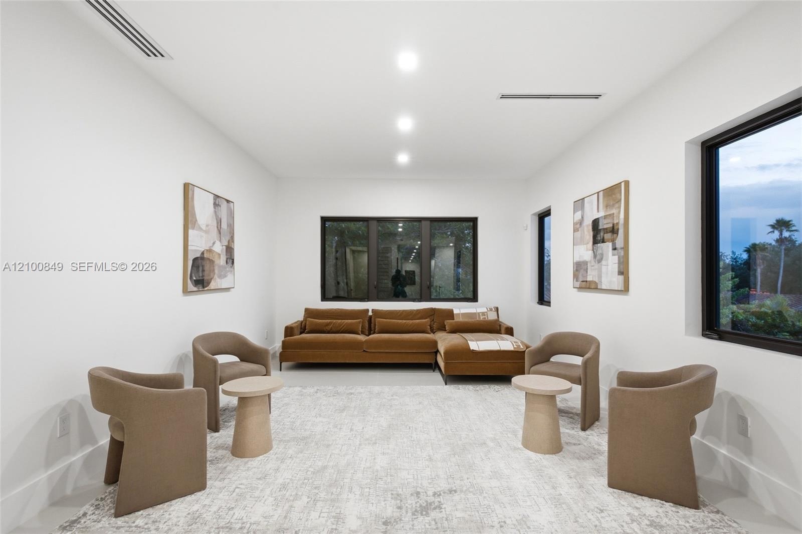 High ceilings with recessed lighting, smooth-finish walls, and dark-framed windows