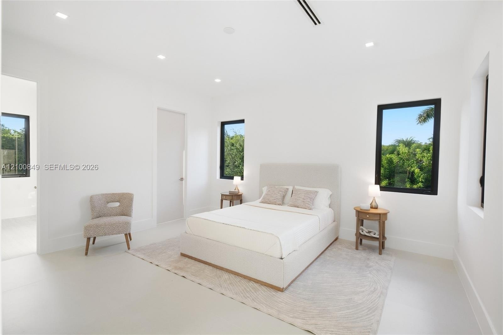 Minimalist interior space featuring large-format tile flooring, recessed ceiling lighting, and black-framed windows