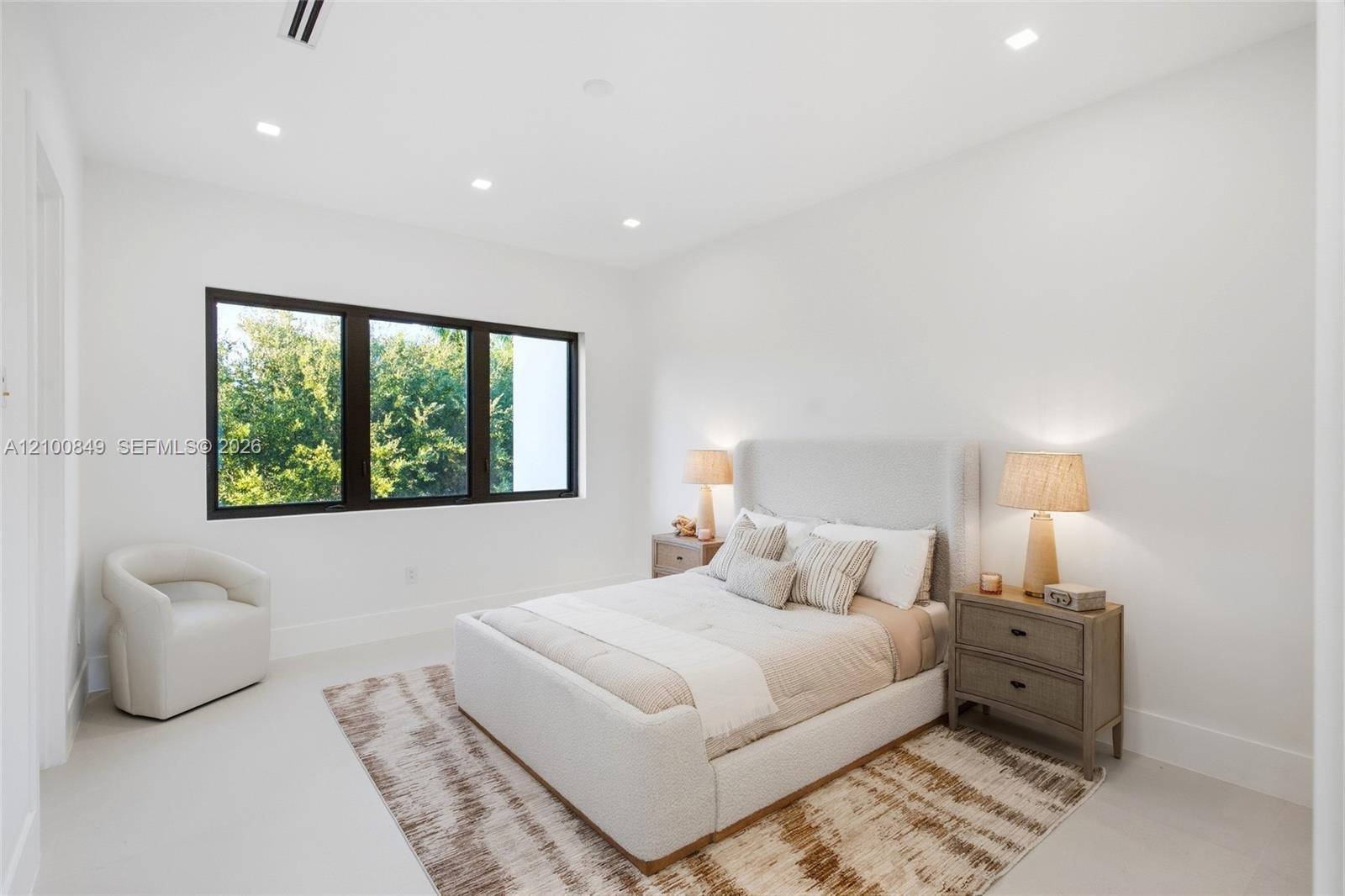 Neutral-toned room featuring large windows with black frames and recessed lighting