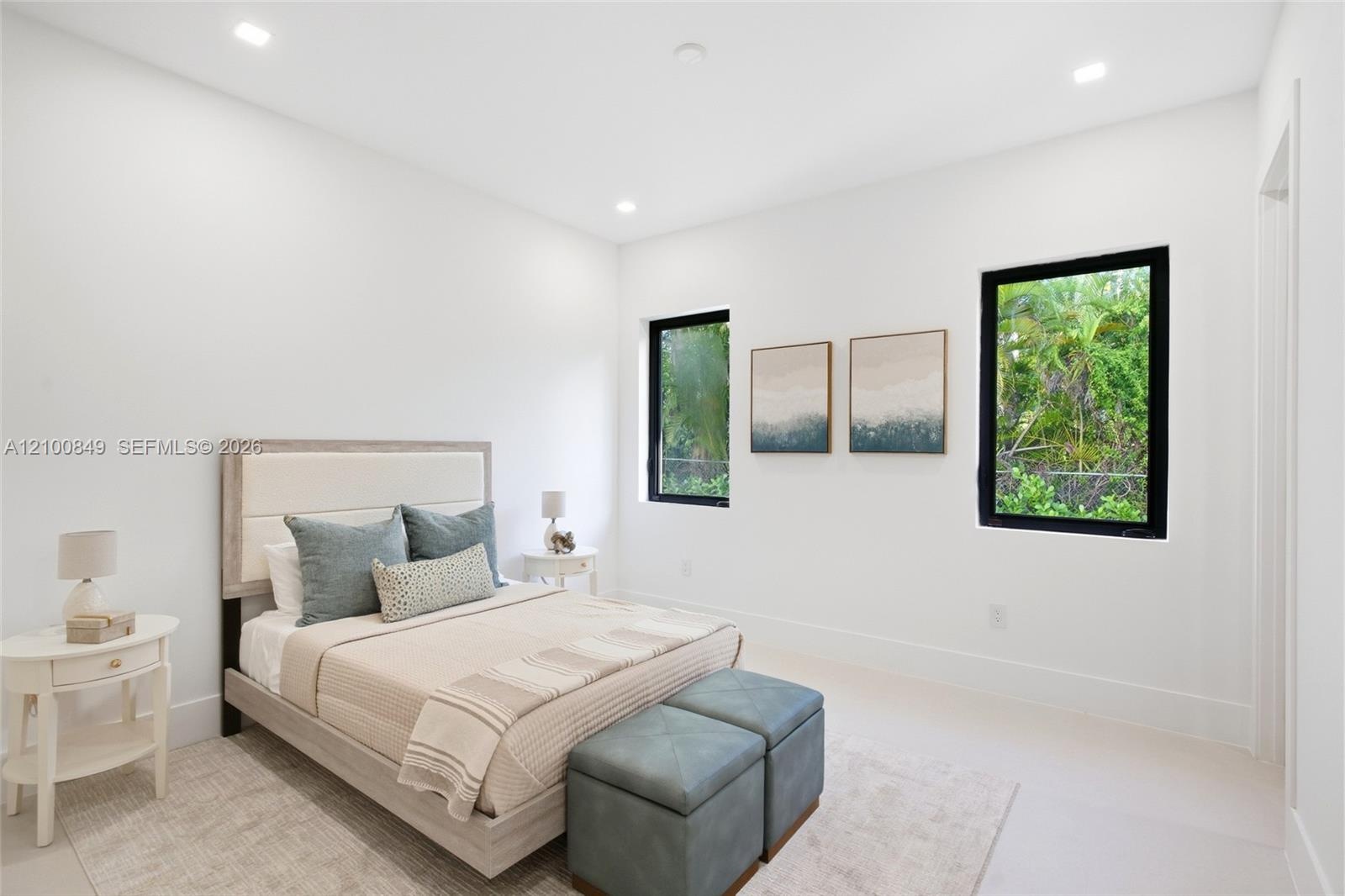 Bright room featuring neutral wall color, recessed lighting, and two windows with black frames