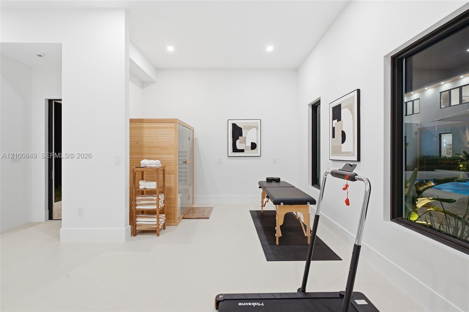 Custom-built wooden sauna, recessed ceiling lighting, light-toned flooring, and expansive windows with black frames