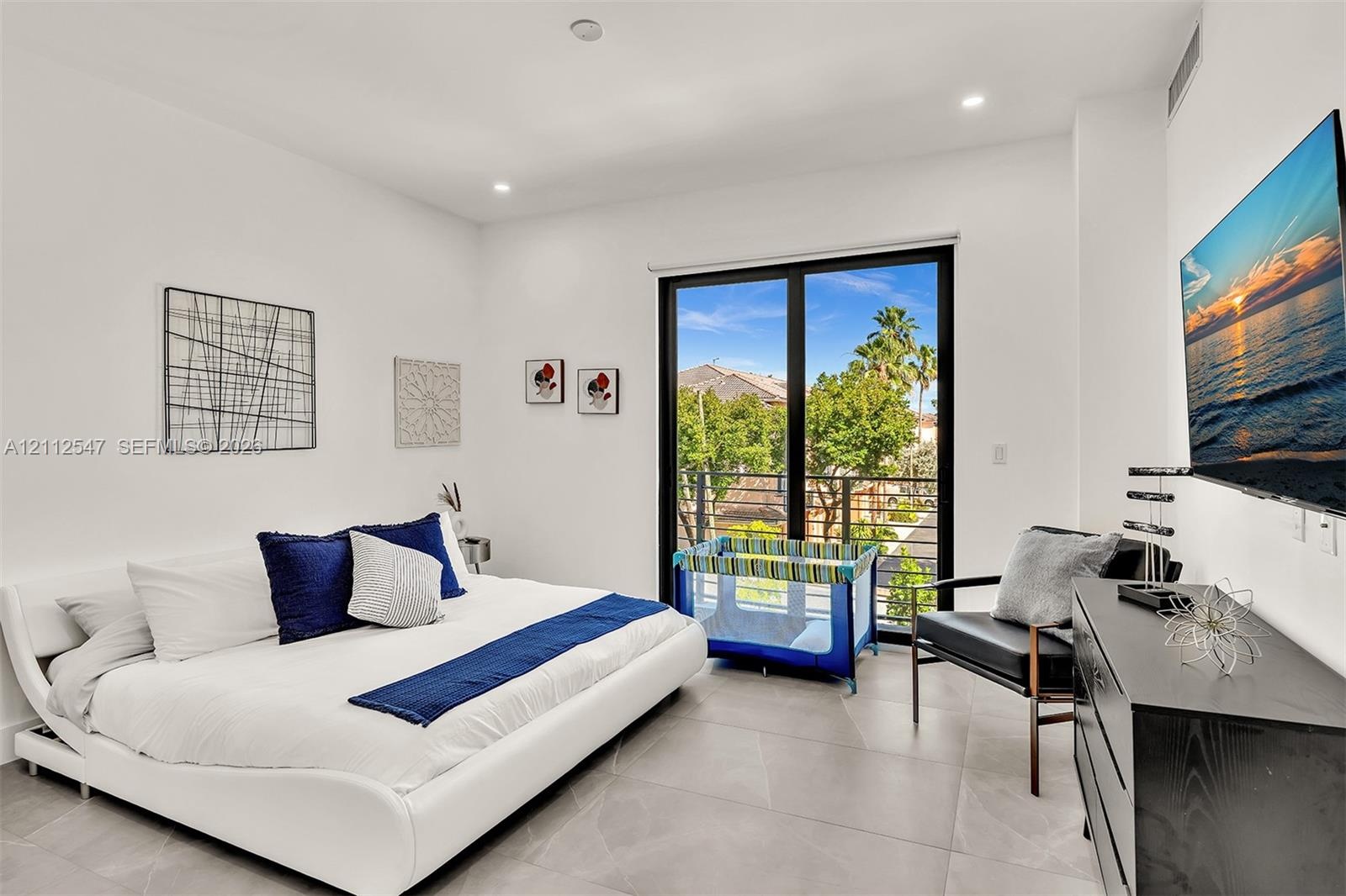 Room featuring large-format tile flooring, recessed lighting, and a black-framed sliding glass door providing egress to a private balcony