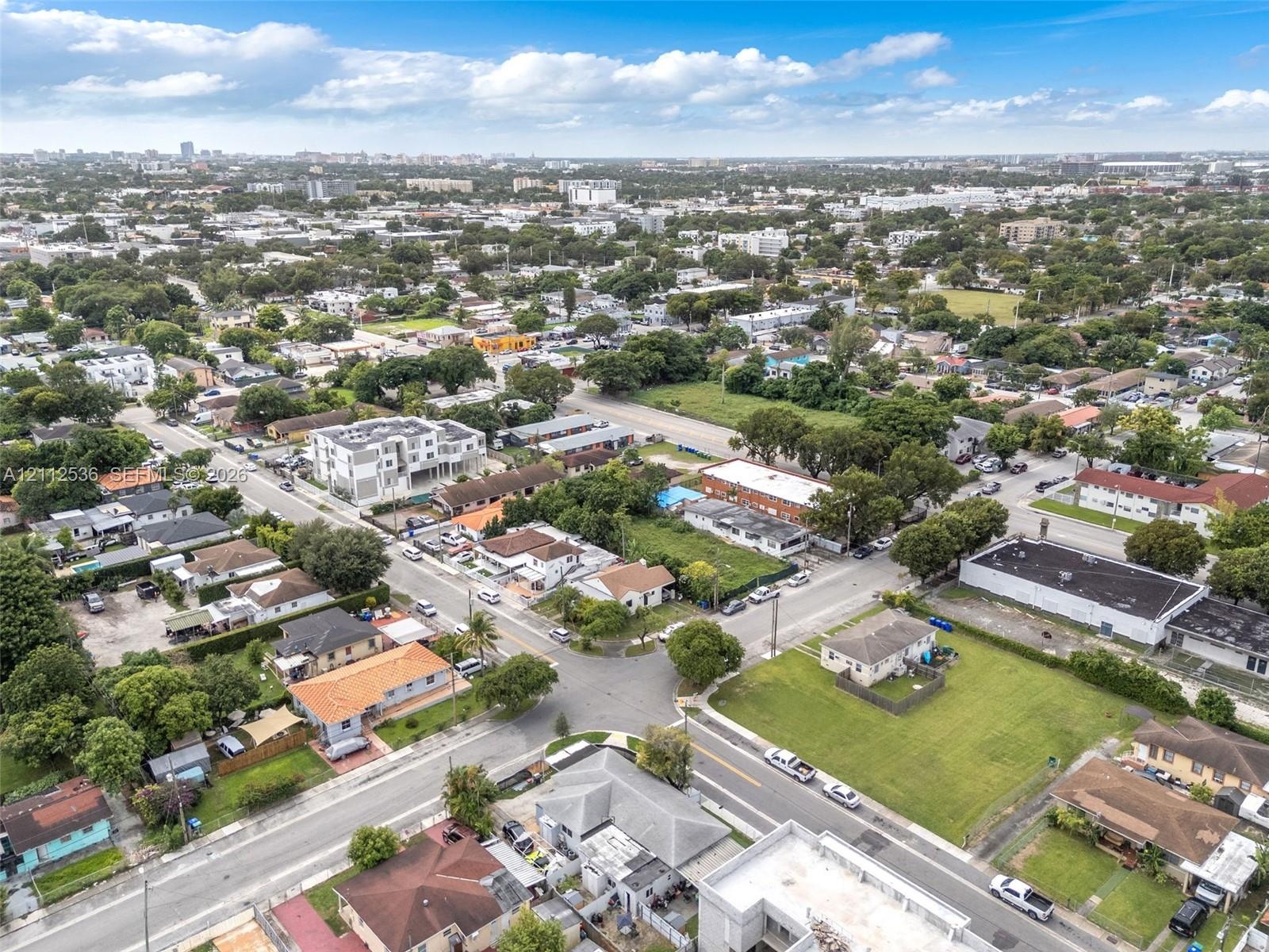 Aerial perspective of the neighborhood featuring varied residential architecture, established tree canopy, and paved street access