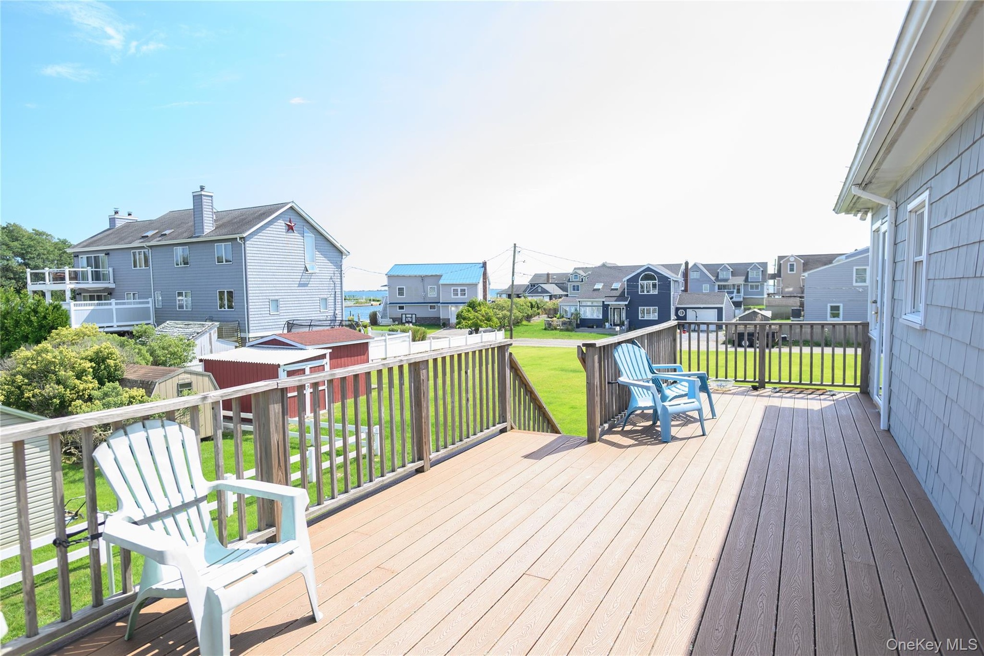 Expansive outdoor deck with wood-finish flooring and wooden railing