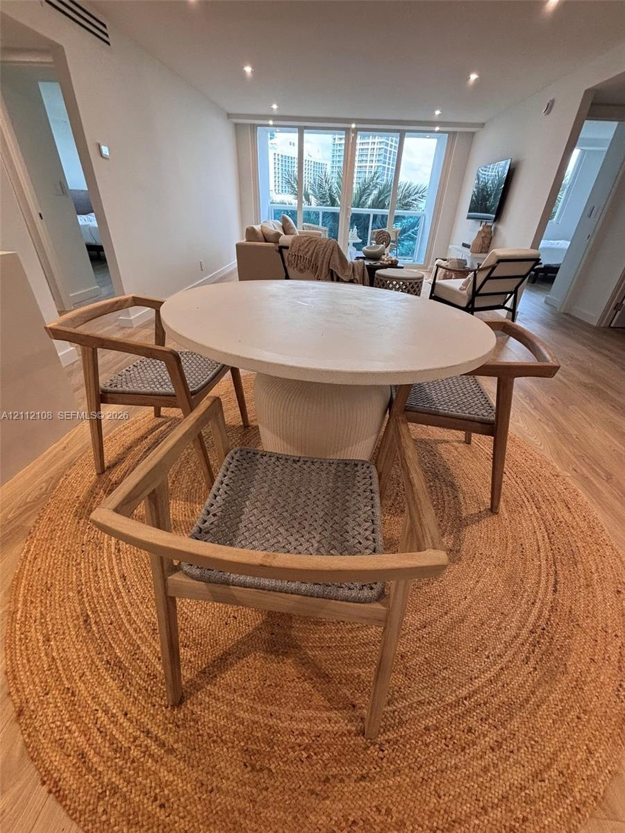 Open-concept area featuring wood-finish flooring, recessed lighting, and floor-to-ceiling windows