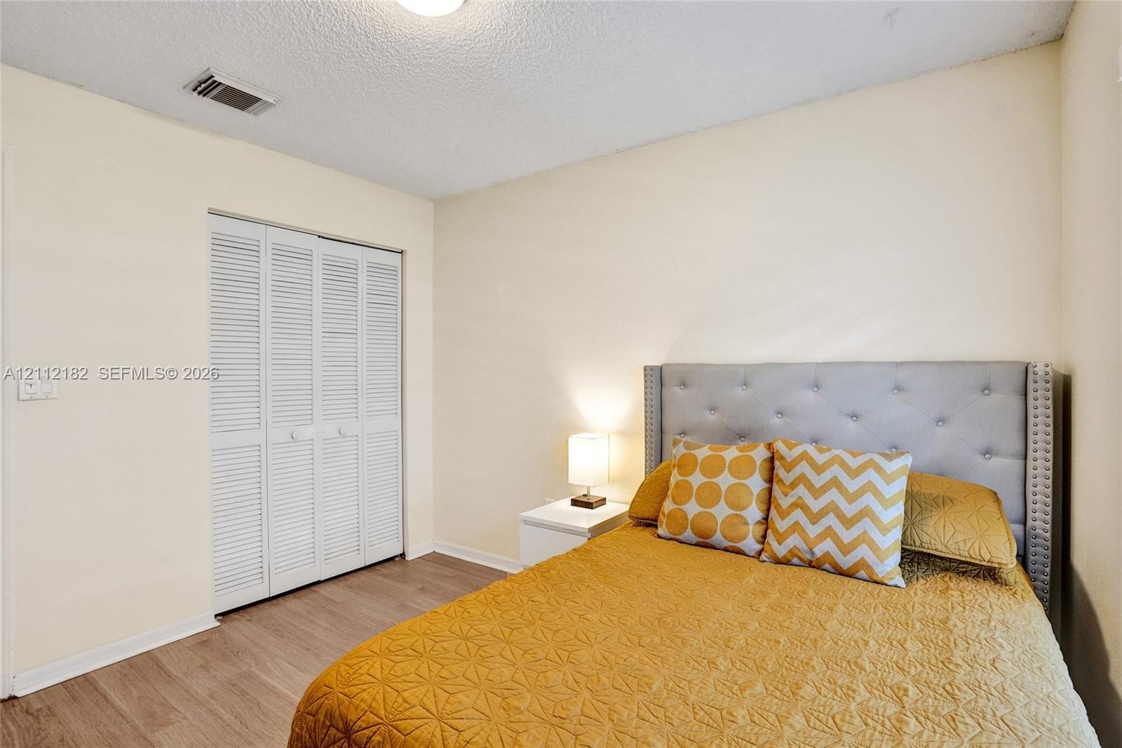Room featuring wood-finish flooring and a bi-fold louvered closet door