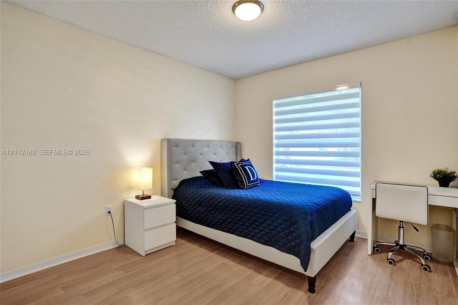 Wood-finish flooring, neutral wall tones, and tiered window shades