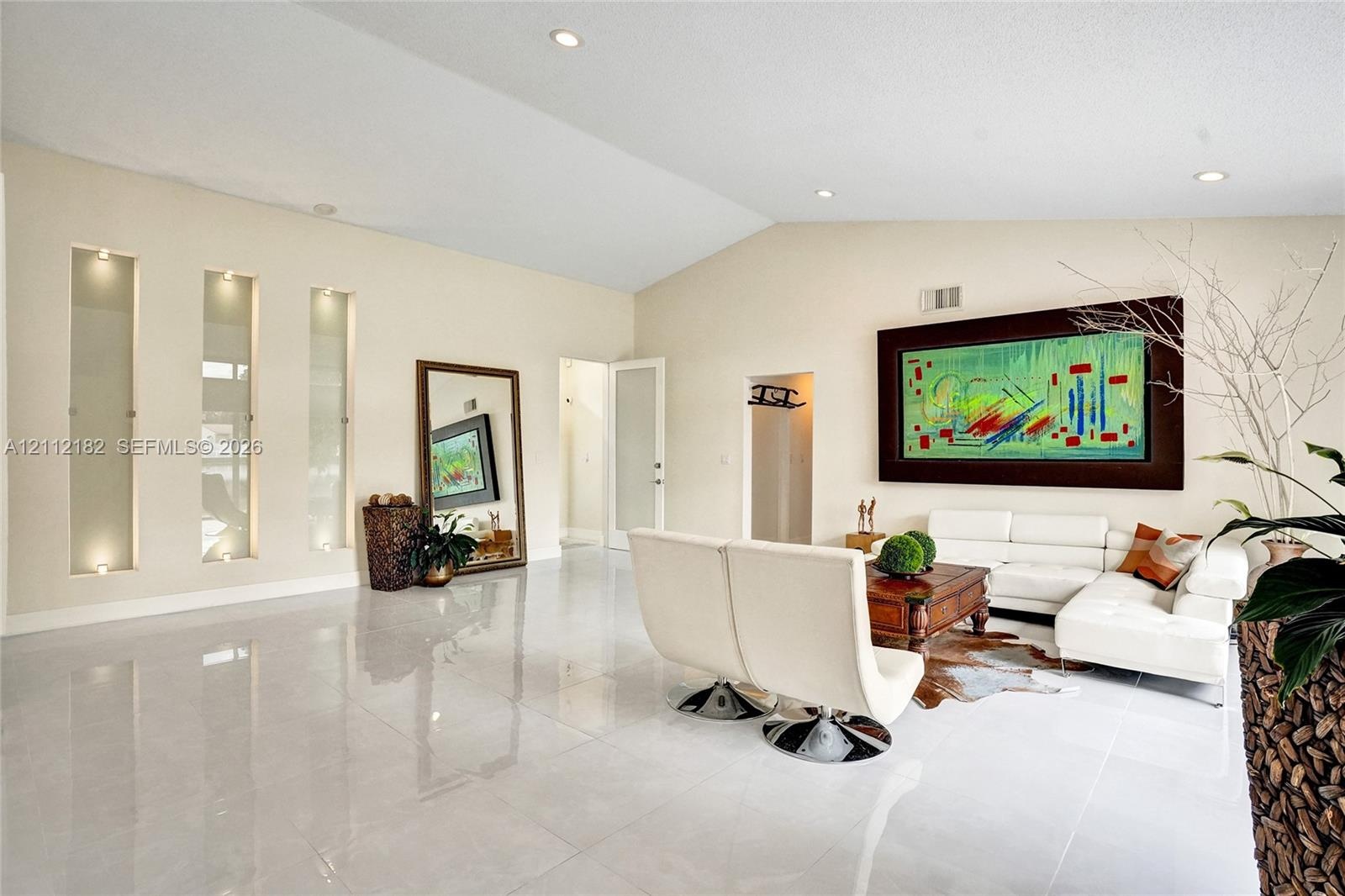 Vaulted ceilings, large-format tile flooring, and integrated recessed wall niches with accent lighting
