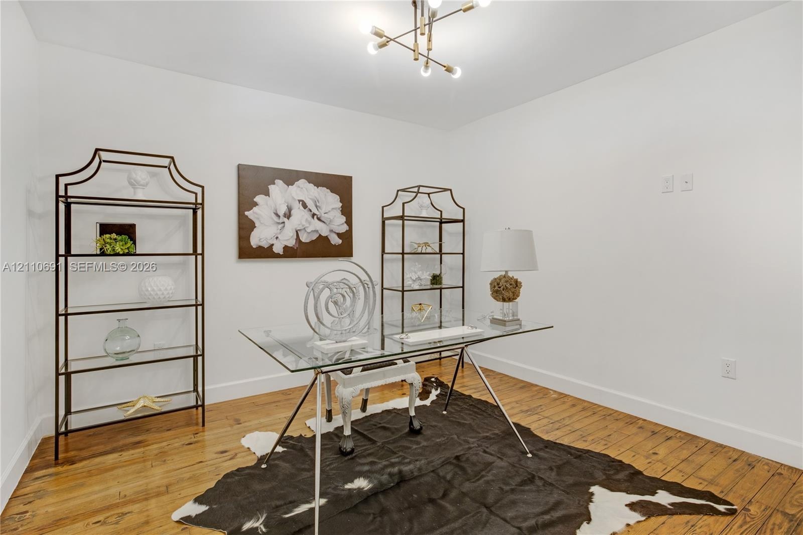 Room featuring wood-finish flooring and a multi-arm modern geometric chandelier